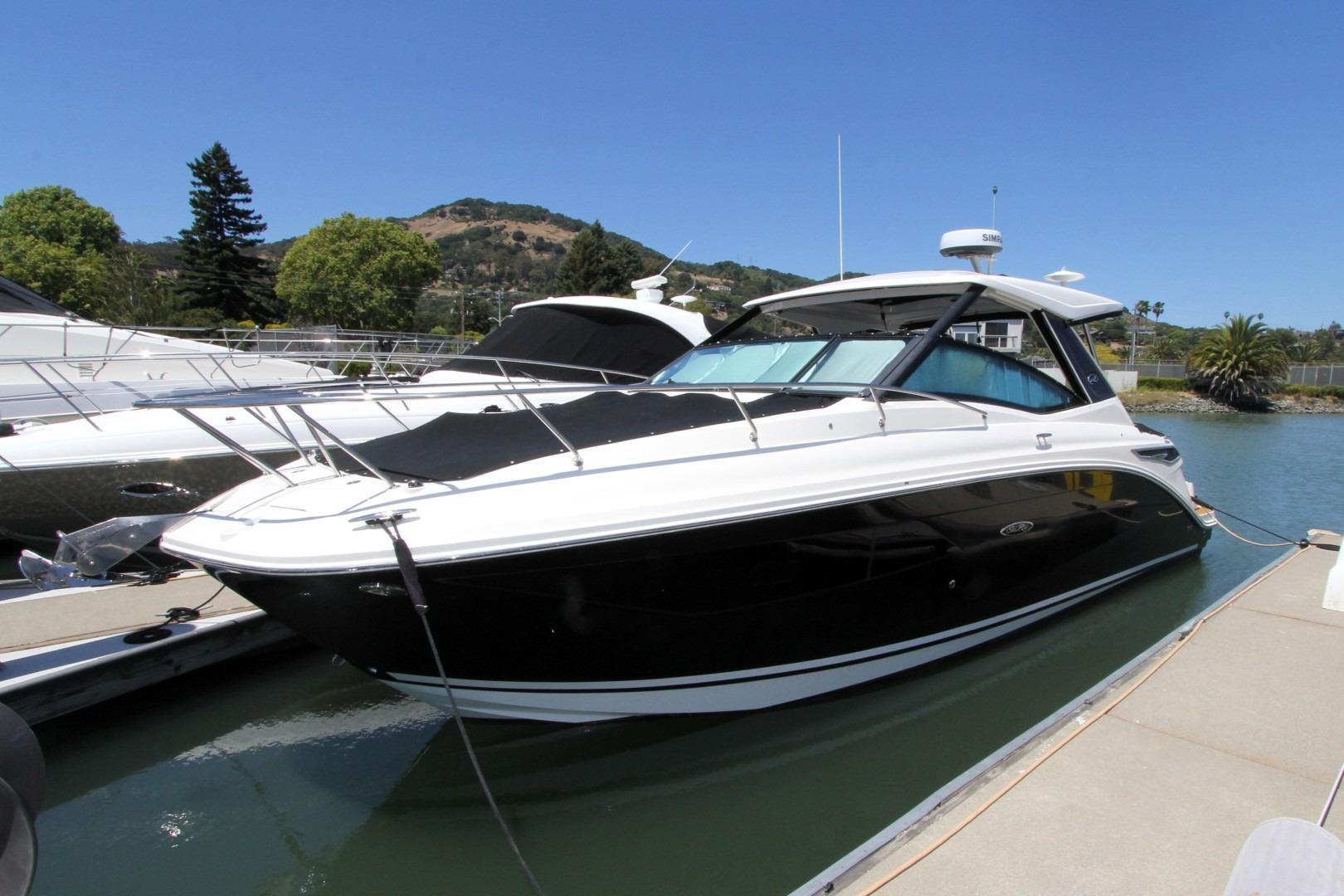 2021 Sea Ray Sundancer 320 Outboard docked at marina under clear blue sky.
