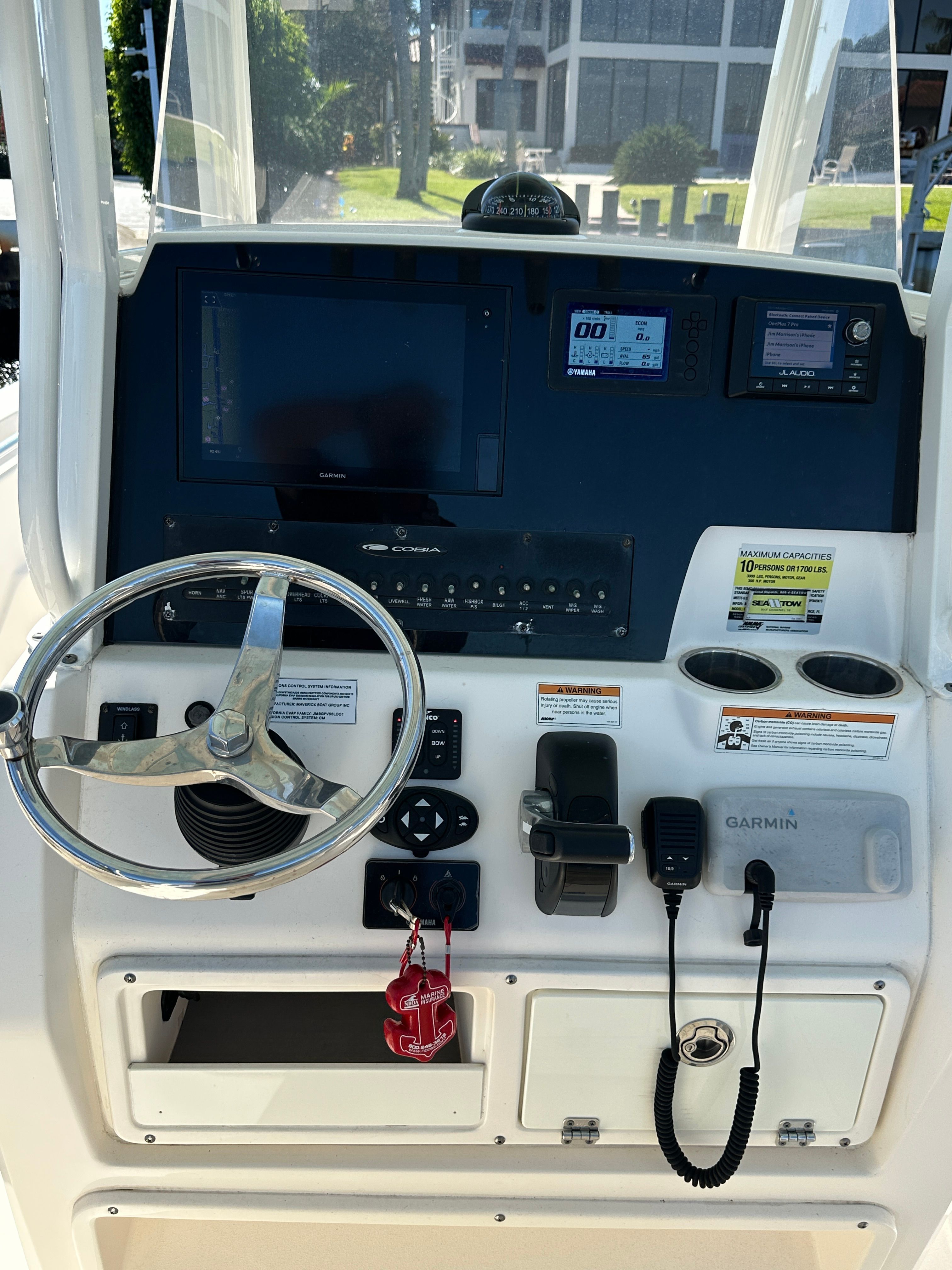 The image shows the helm of a 2022 Cobia 240 Center Console boat with modern instruments.