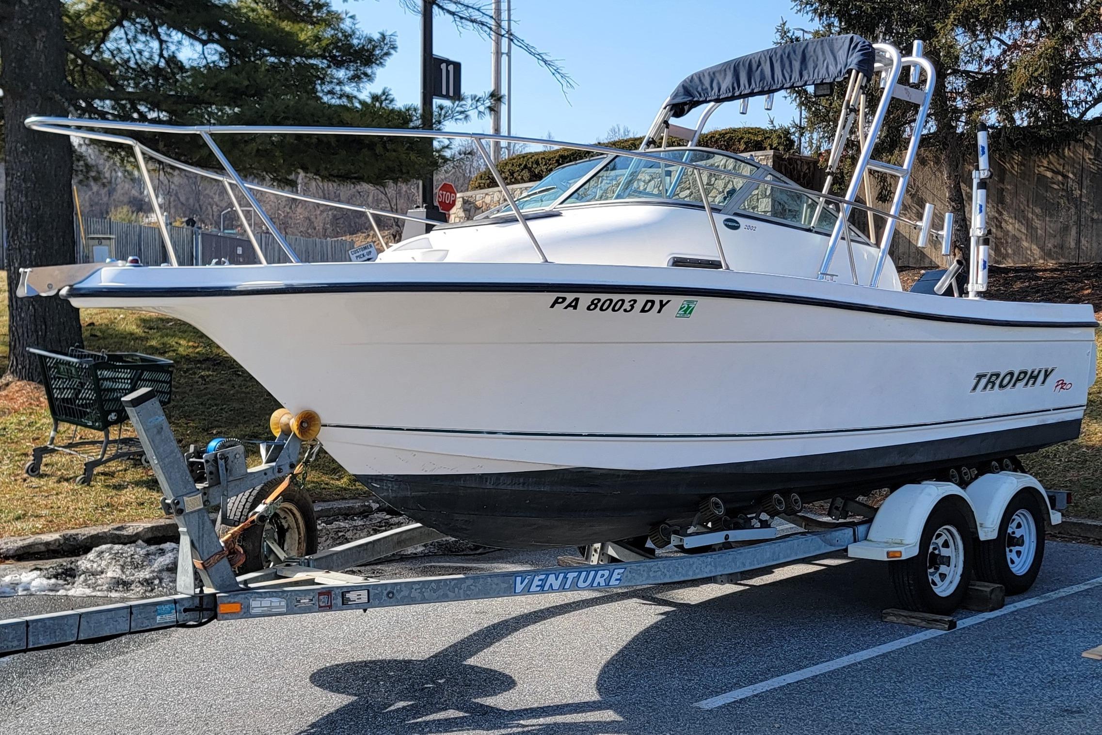 2003 Trophy 2002 Walkaround boat on trailer, parked outdoors.