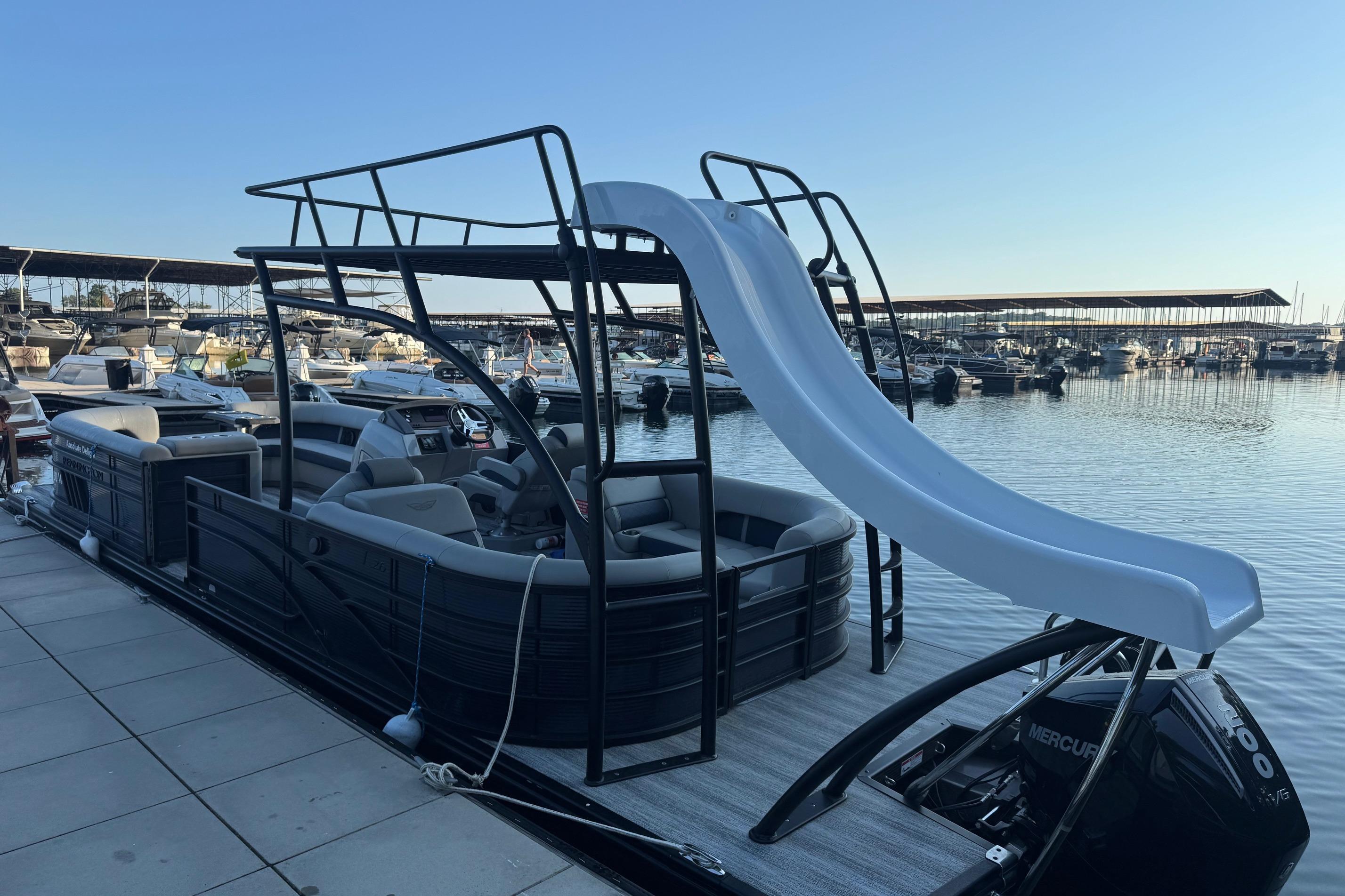 2025 Bennington 26 L Top Deck pontoon boat with slide, docked at marina.