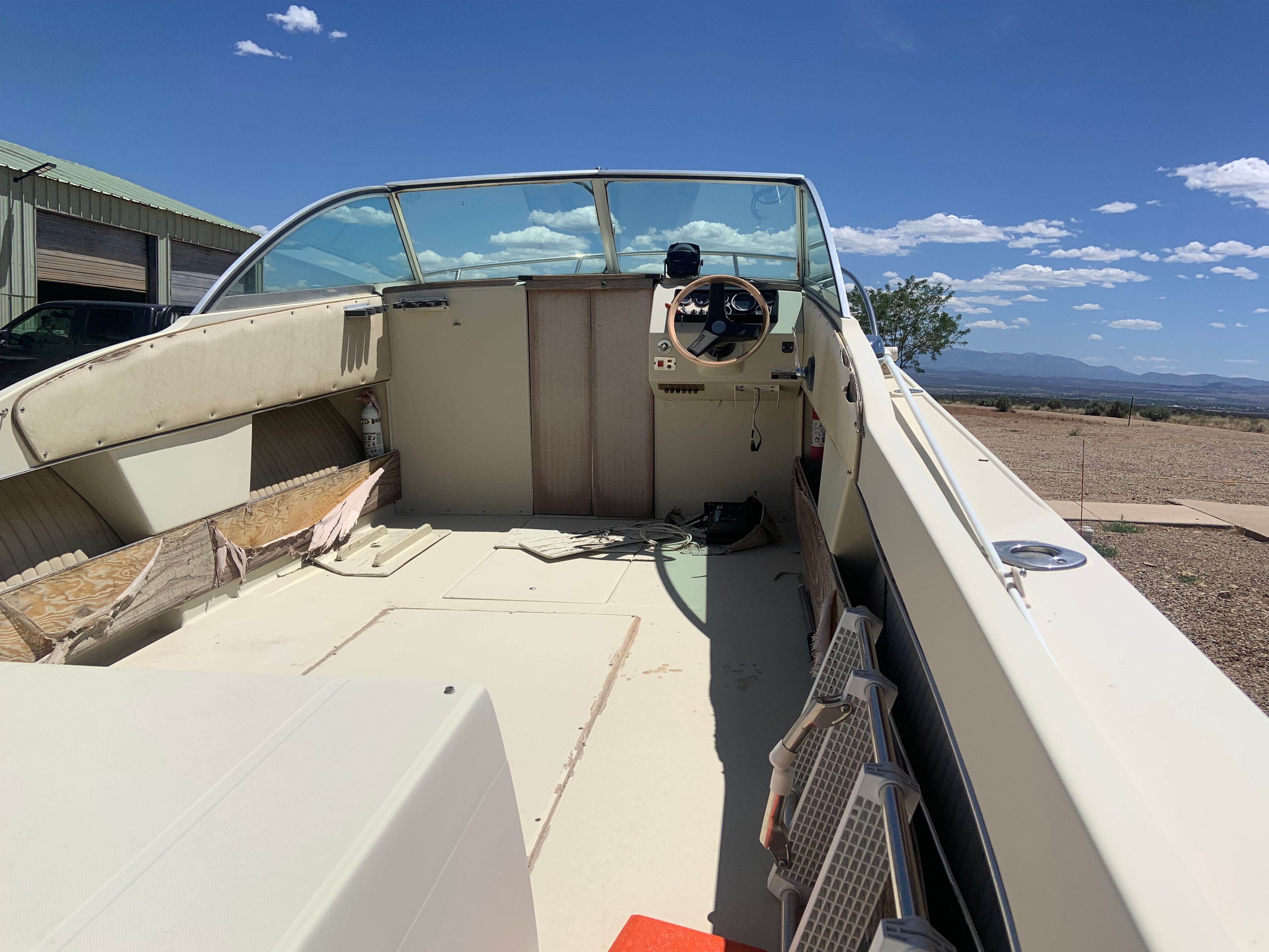 Interior view of a 1981 Skipjack 20’ boat with helm and seating area.