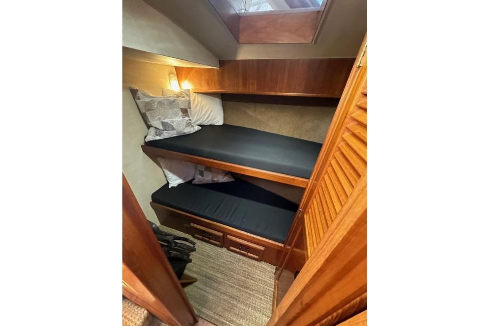 1985 Egg Harbor 33 Sedan cabin with wooden bunk beds and cozy lighting.