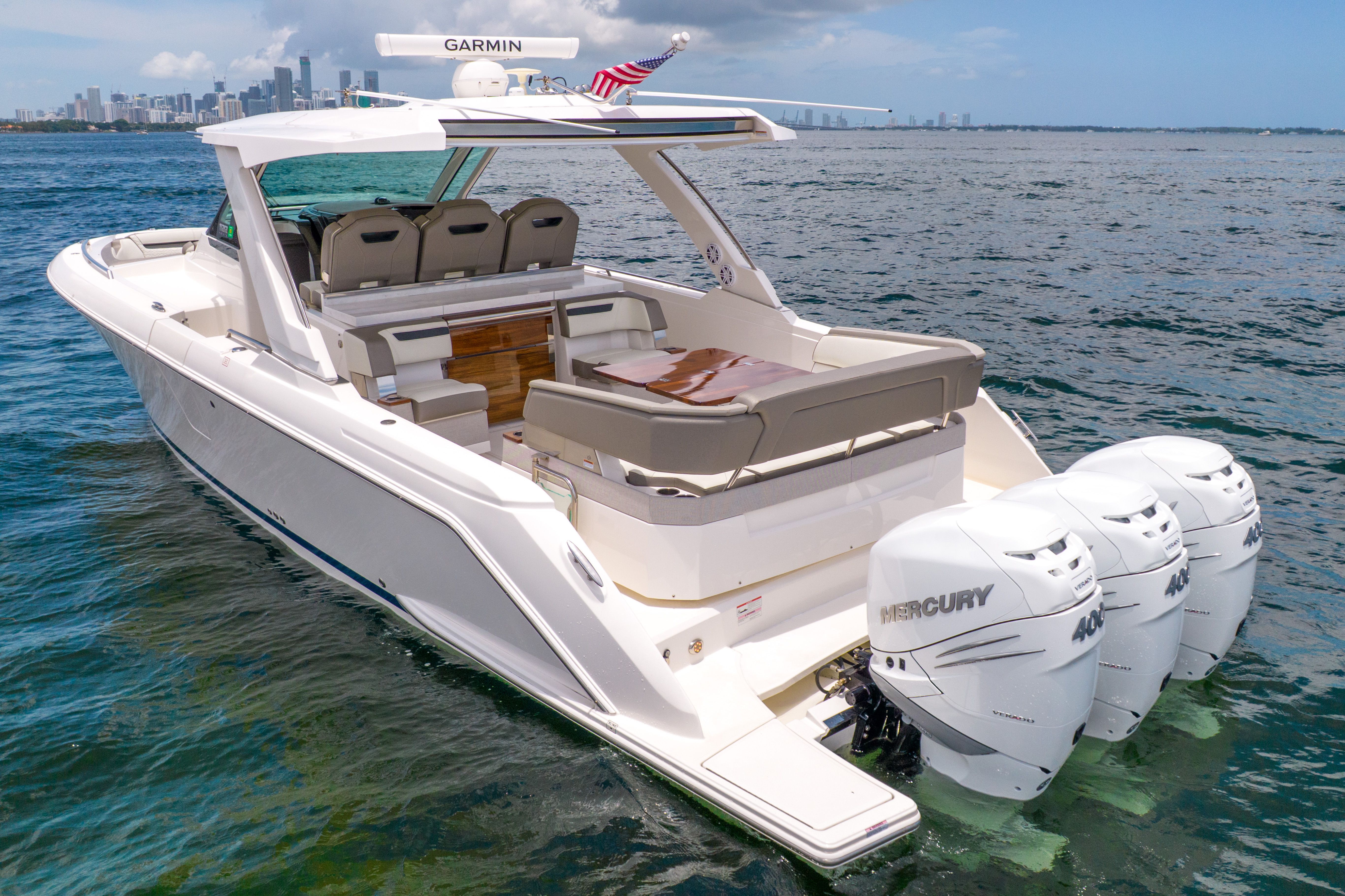 2023 Tiara Yachts 38 LS on the water with three Mercury engines and a modern cabin.