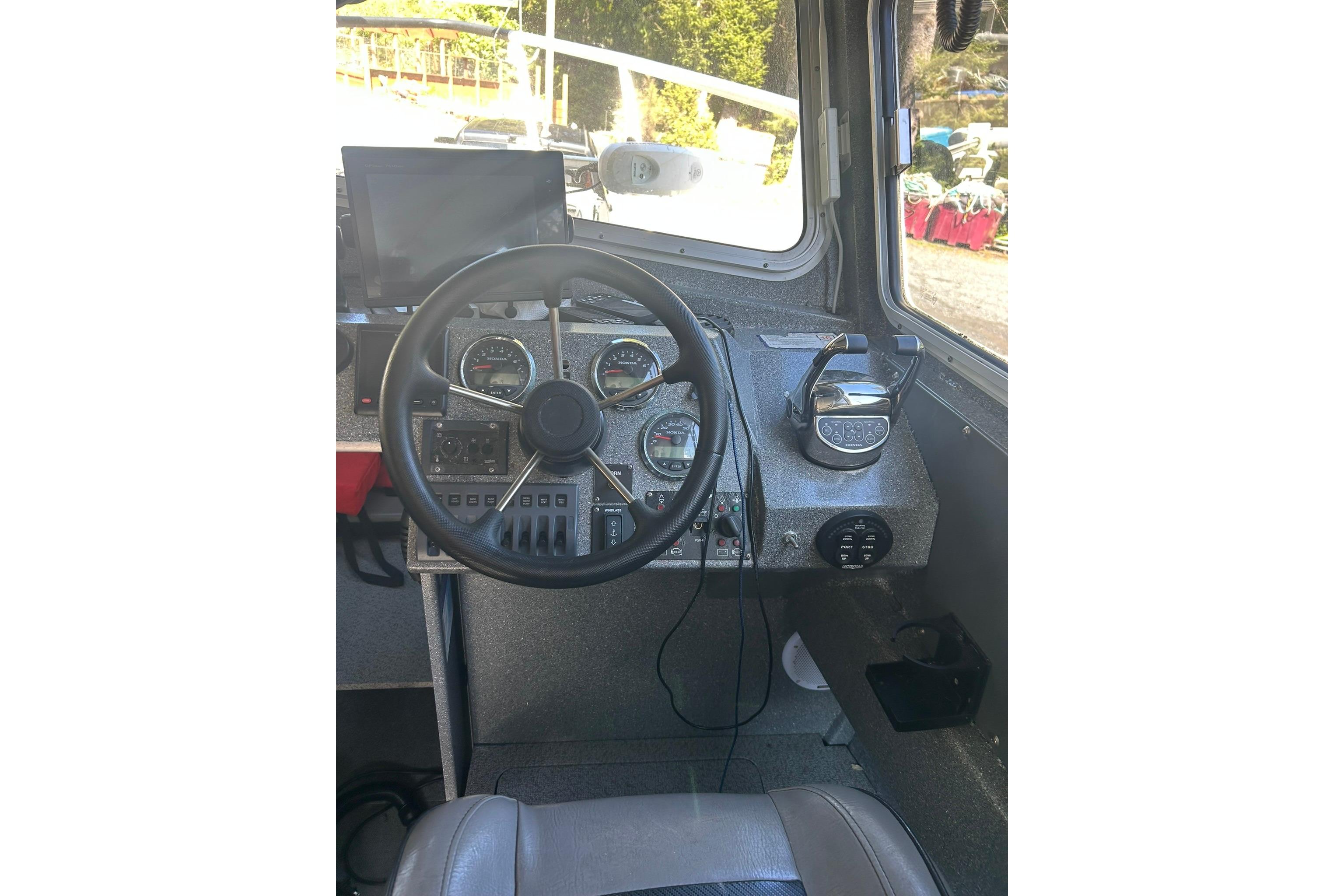 Interior view of 2016 North River 29 OFFSHORE boat cockpit with steering wheel and controls.