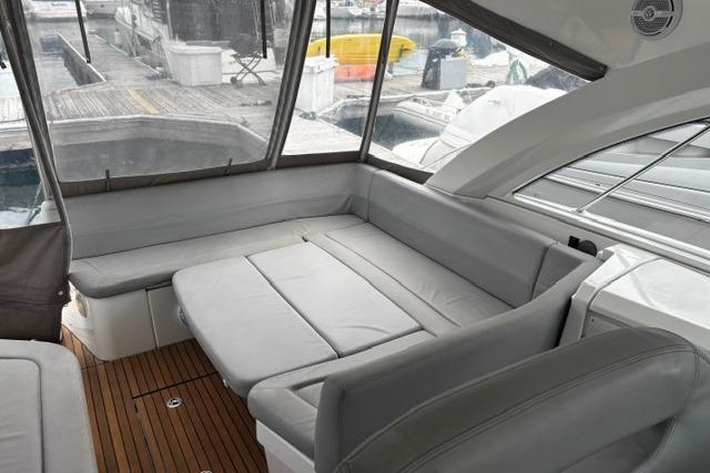 Interior of 2013 Beneteau Gran Turismo 38 yacht with gray seating and wooden flooring.