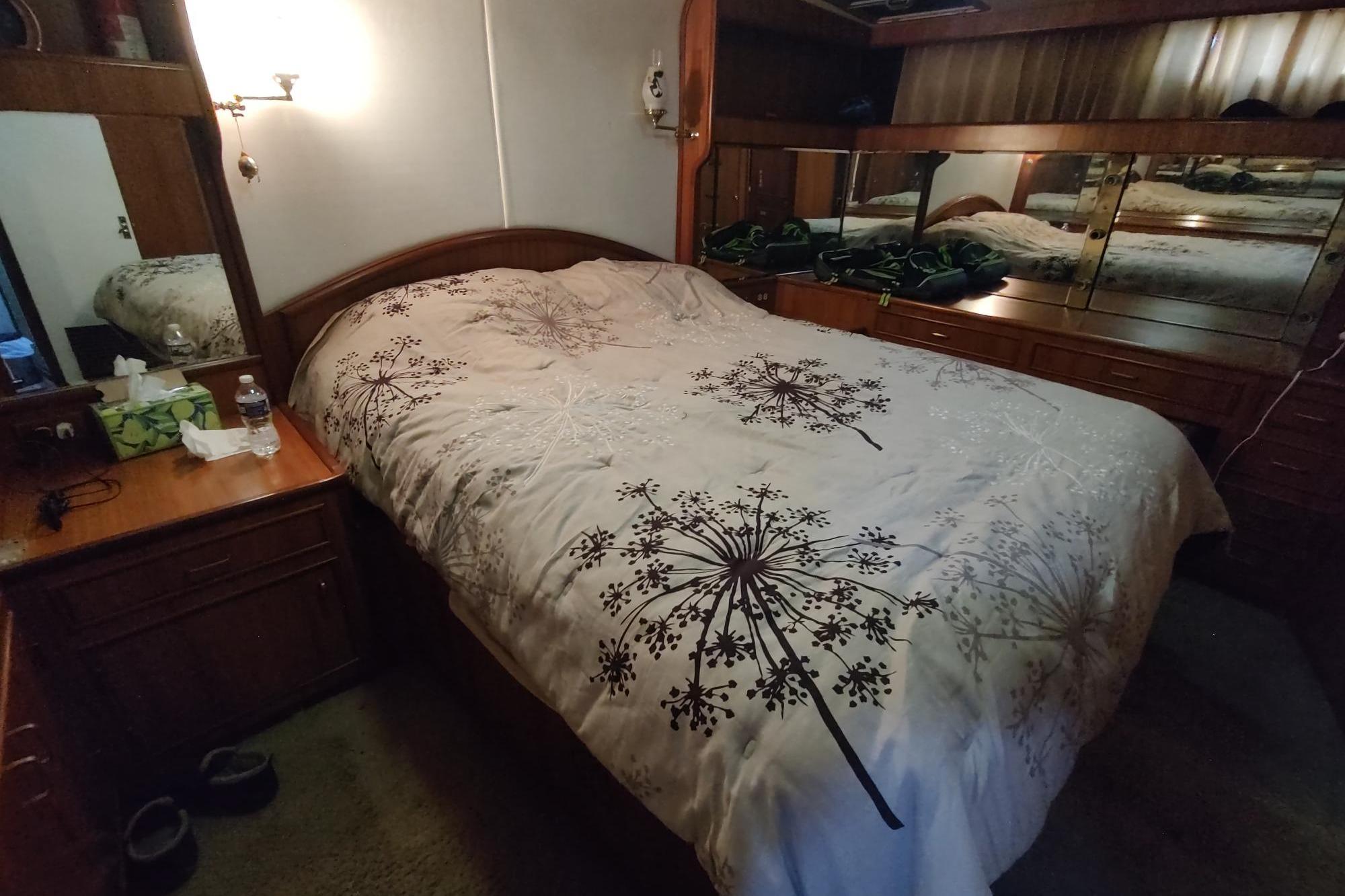 Cozy bedroom in 1989 Hyatt Double Cabin Motoryacht with floral bedding and wooden furnishings.