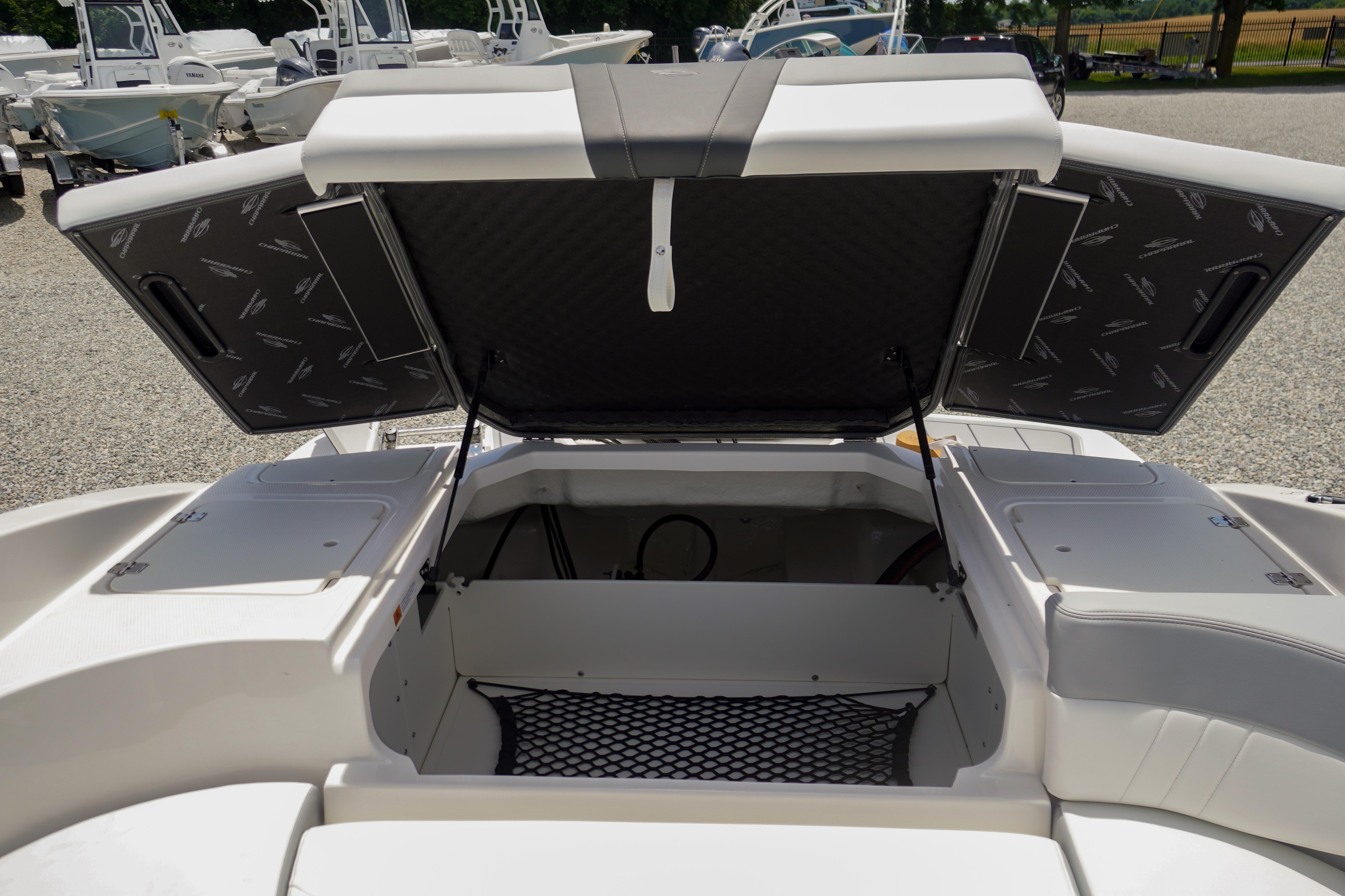 2026 Chaparral 23 SSi OB boat storage compartment open, showcasing spacious interior.