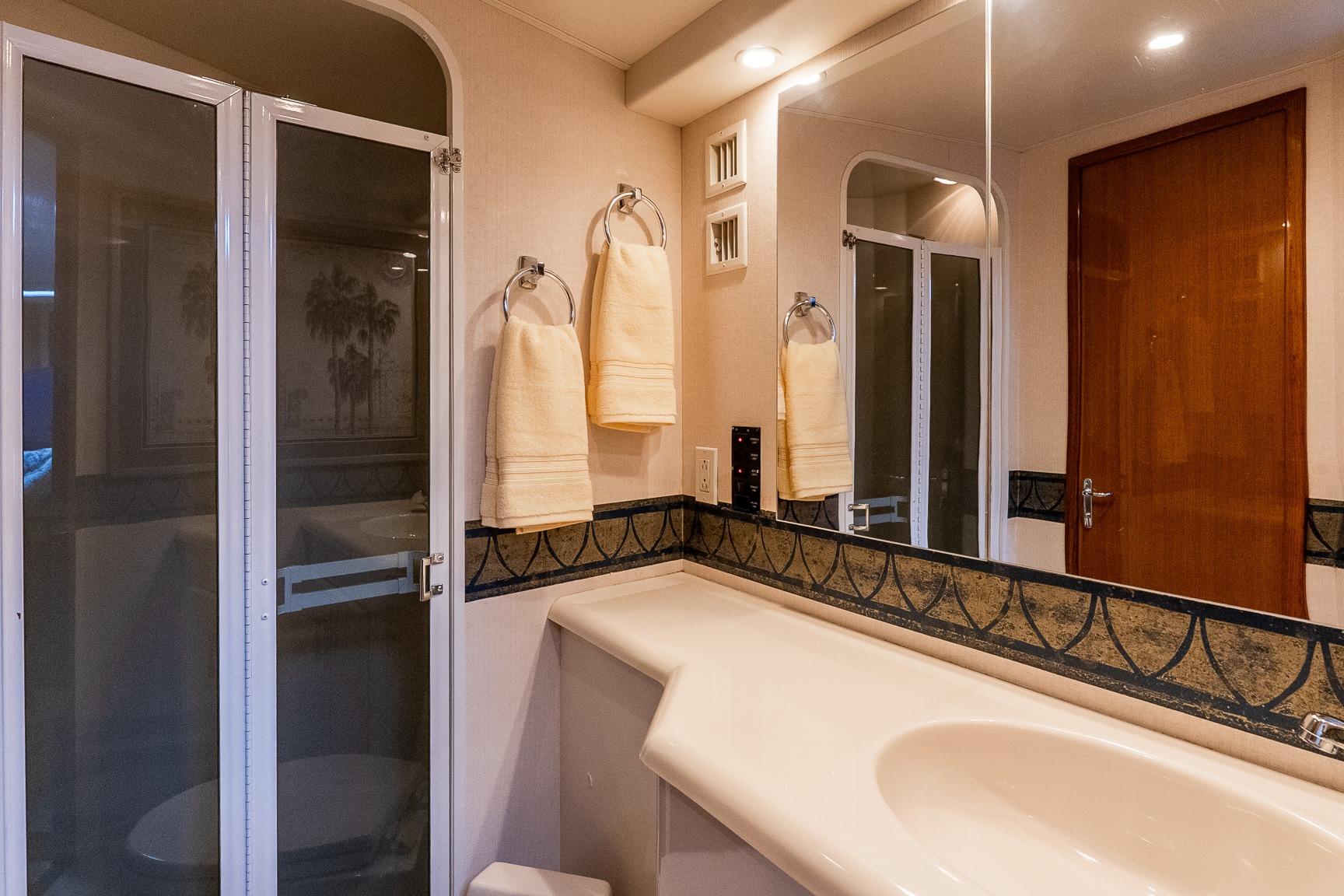 Luxurious bathroom in 2000 Viking 50' Convertible yacht with elegant fixtures and spacious shower.