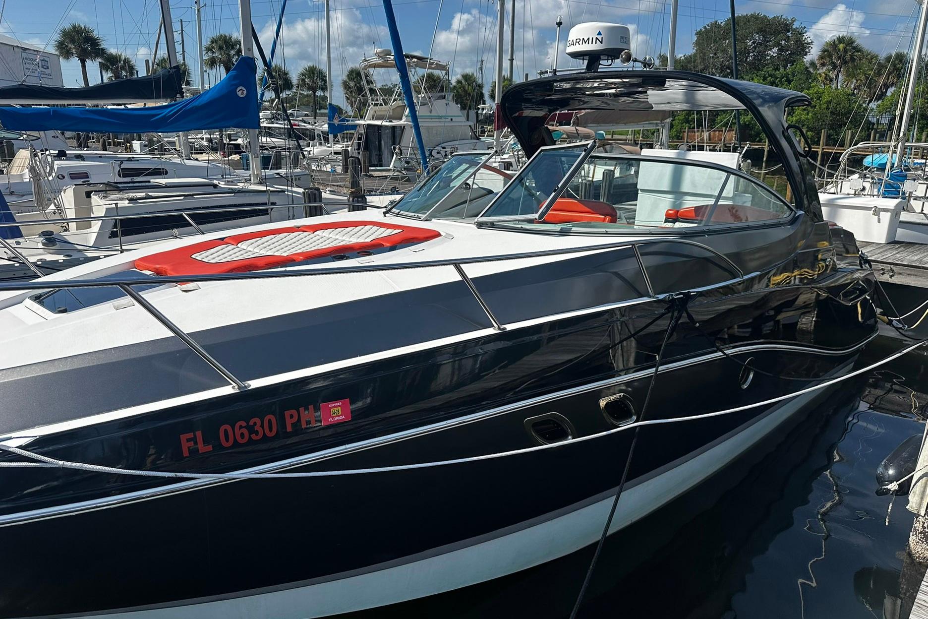 2012 Rinker 310 Express Cruiser LE docked at marina, sleek design, sunny day.