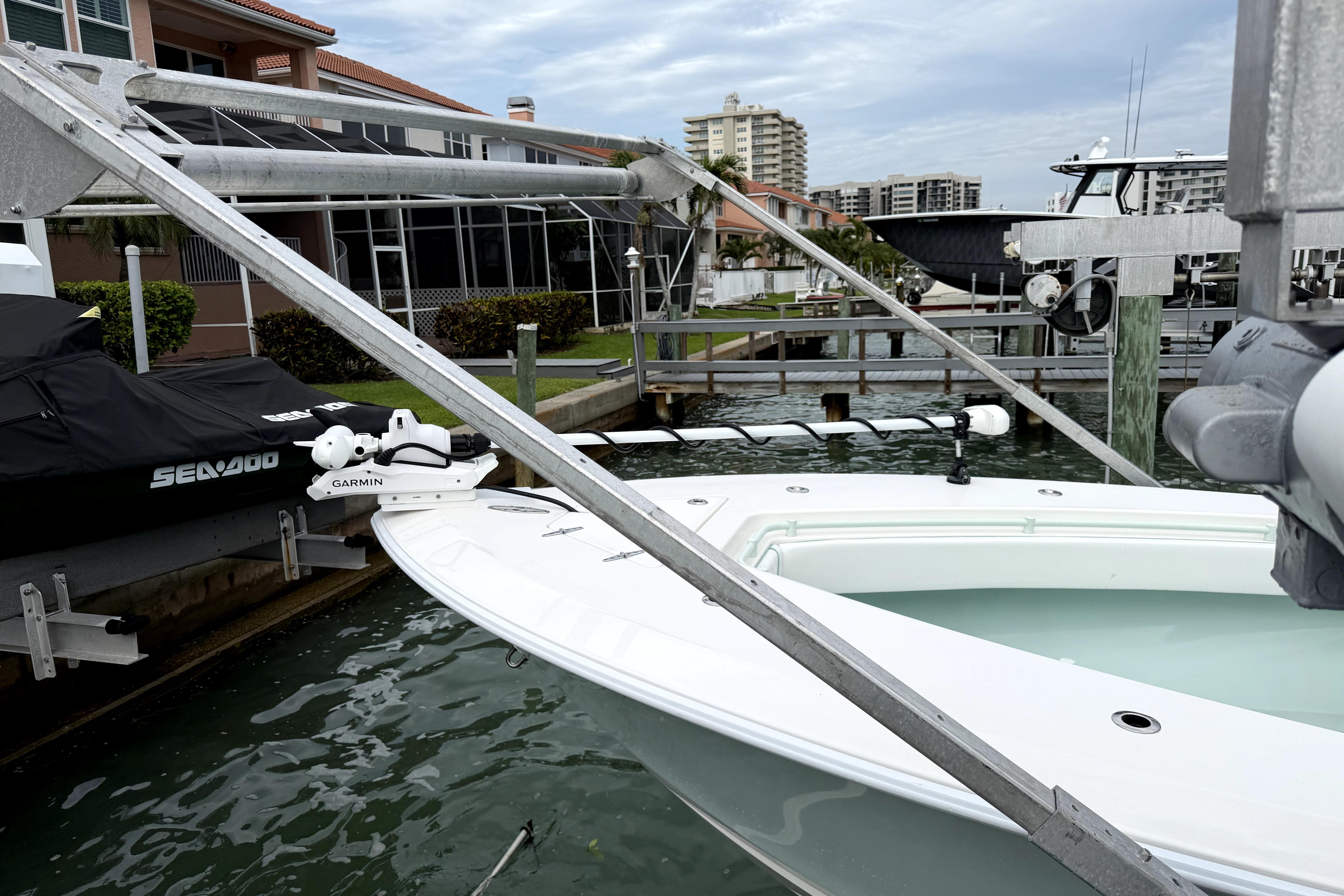 2019 Contender 30 ST boat docked with Garmin equipment, near waterfront homes.