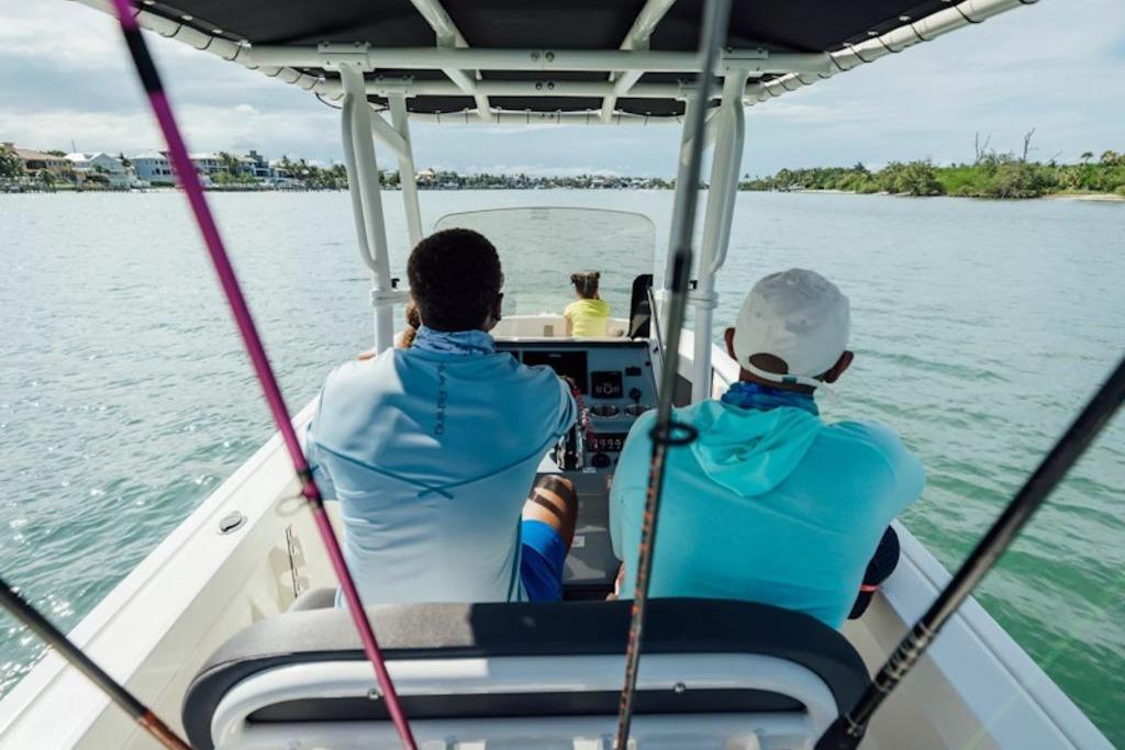 2026 Bayliner Trophy T20CC boat with passengers cruising on a scenic waterway.