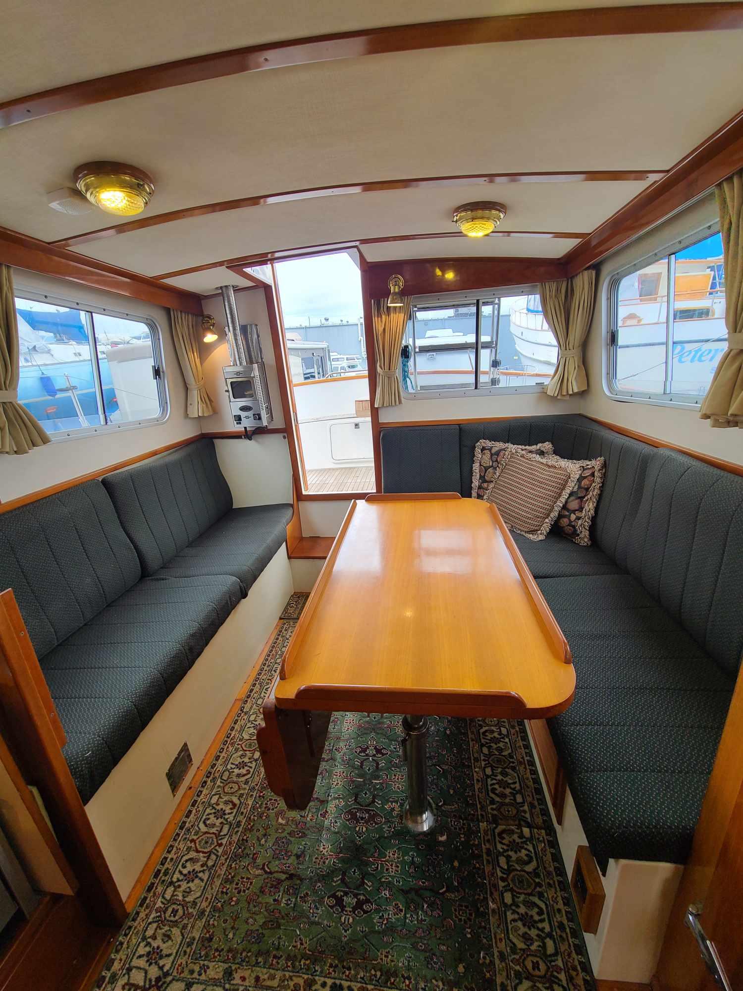 Interior of 1989 Eagle 32 Trawler with cozy seating and wooden table.