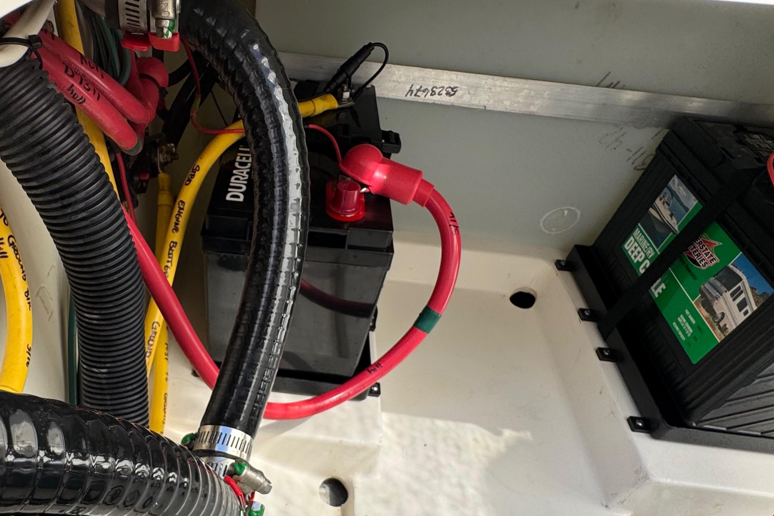 Battery compartment of 2022 Pursuit DC 266 Dual Console boat with cables and connections.