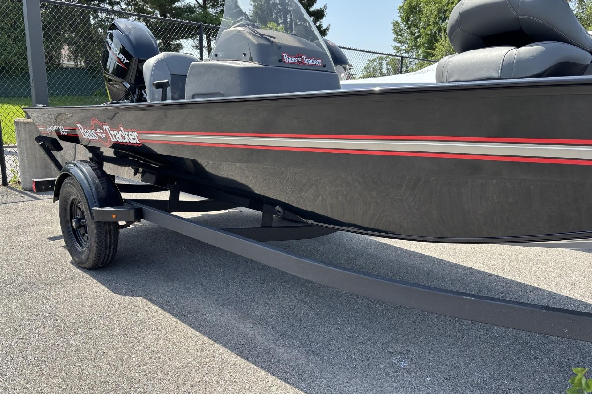 2026 Tracker Bass Tracker Classic XL boat on trailer, black with red accents, parked outdoors.