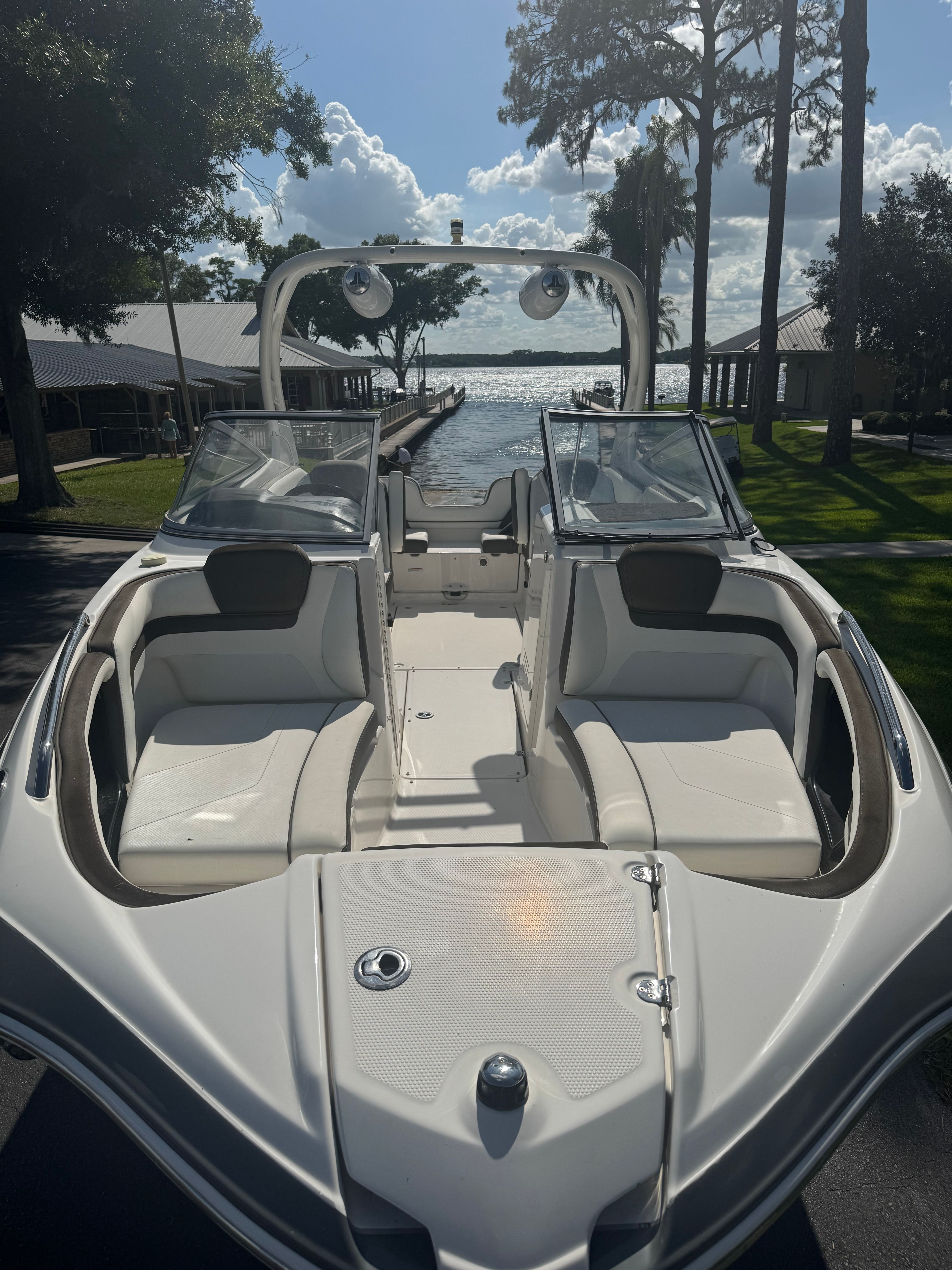 A sleek motorboat with white seating and an open deck, positioned on a trailer.