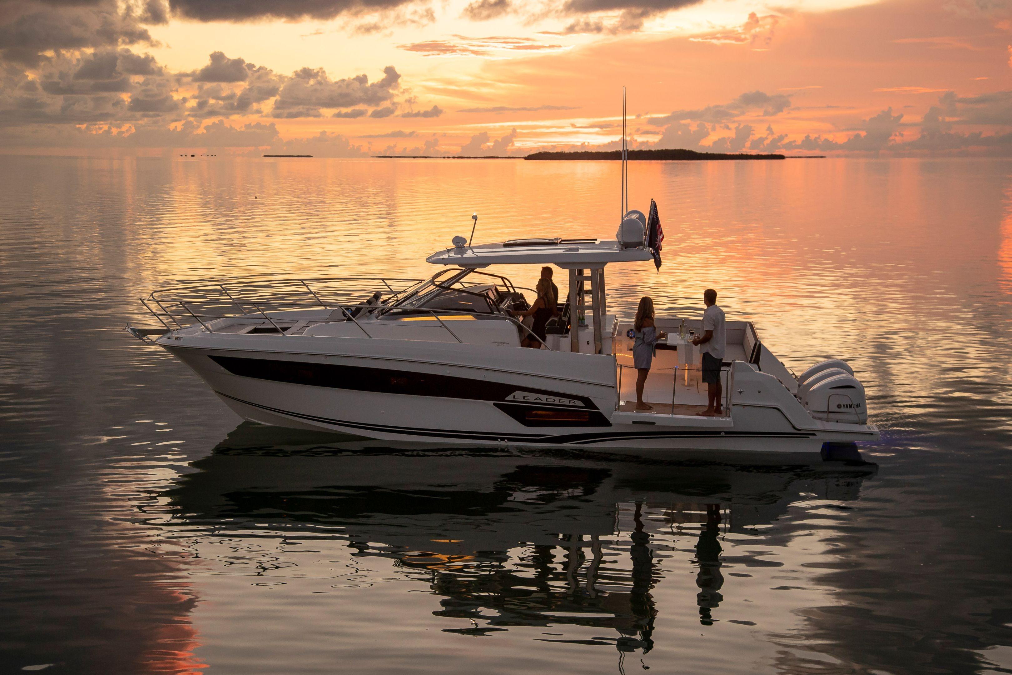 2026 Jeanneau Leader 12.5 WA yacht at sunset with people onboard, reflecting on calm water.