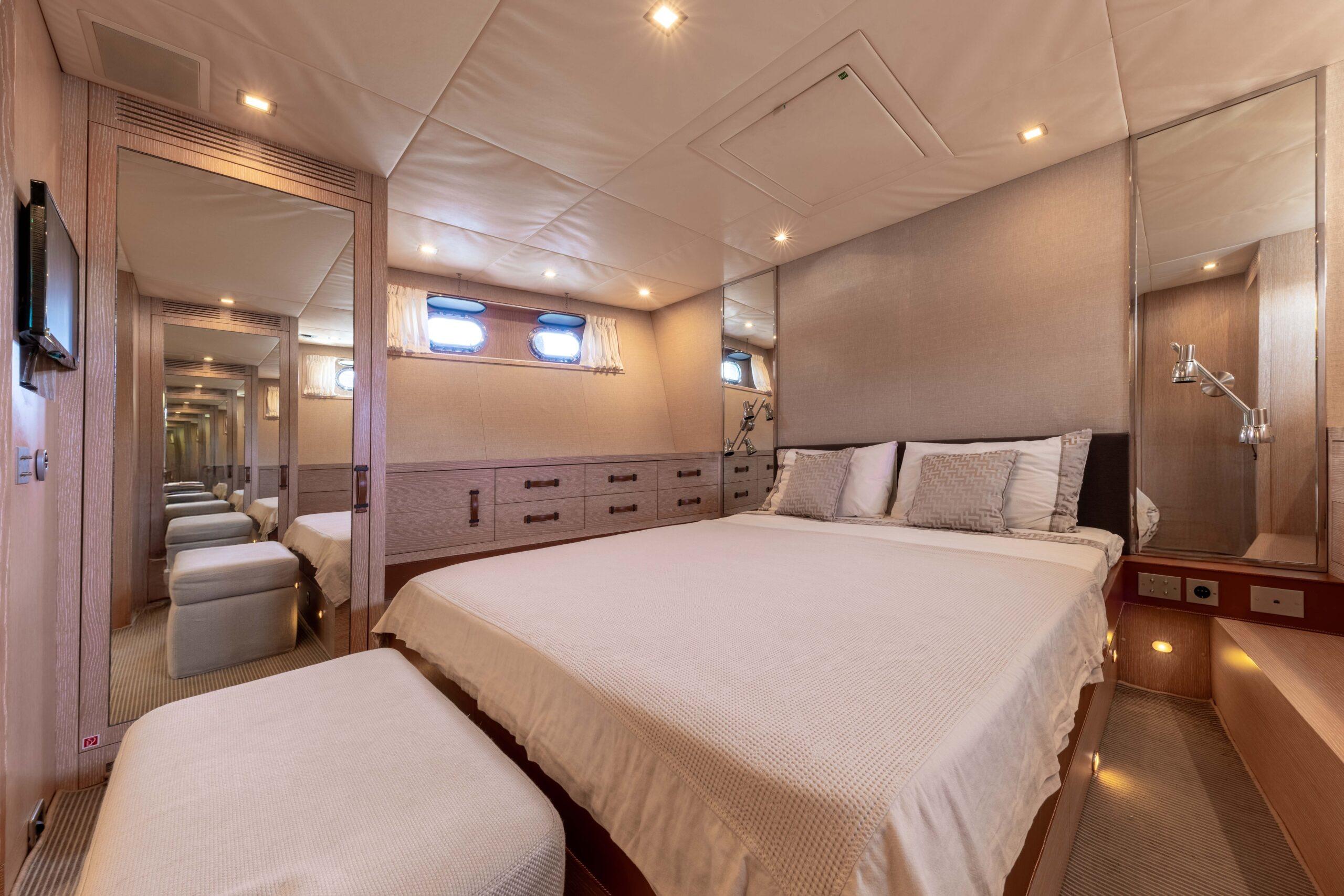 Luxurious bedroom interior of 2006 Mangusta 80 yacht with elegant decor and ambient lighting.