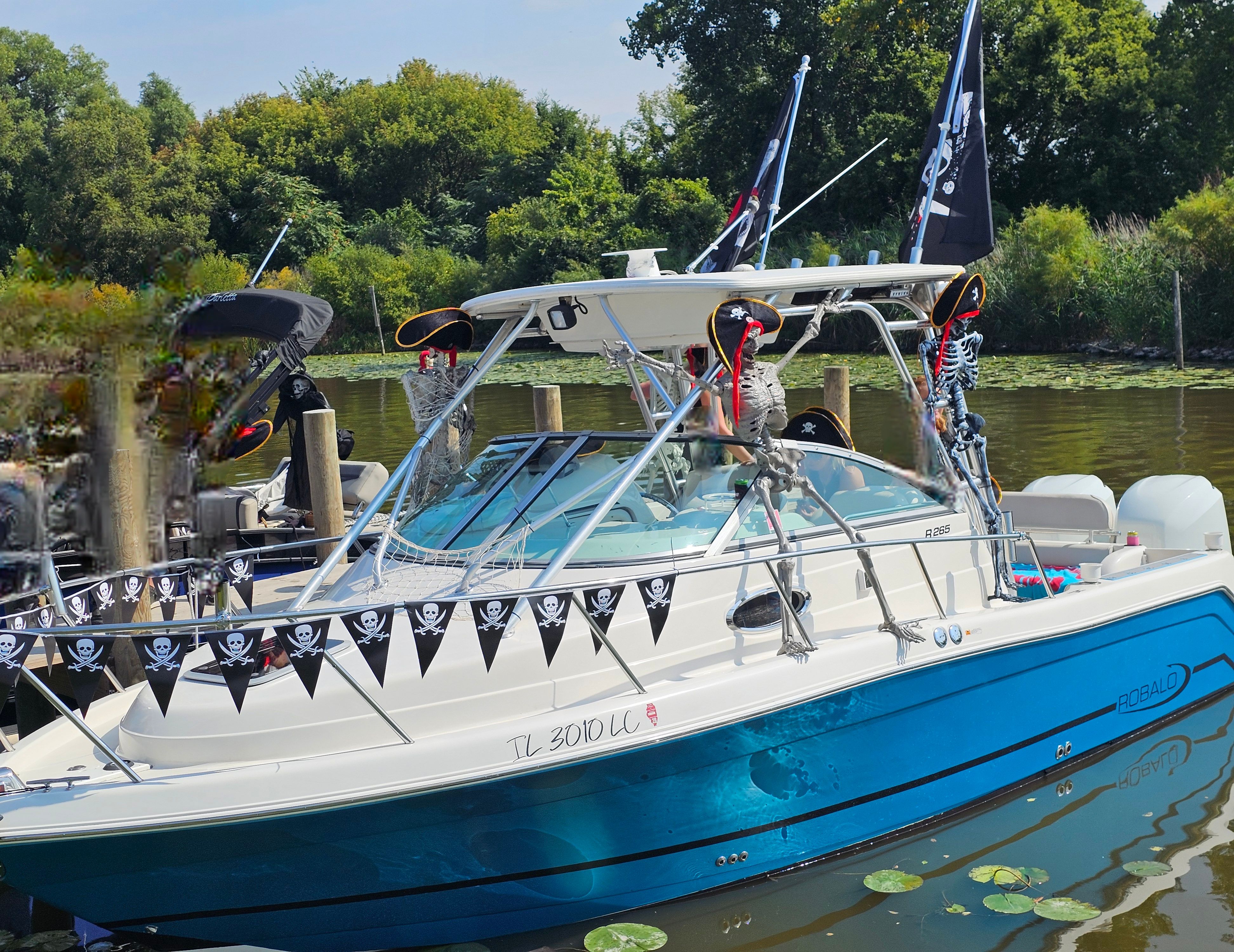 2005 Robalo R265 Walkaround boat with pirate decorations at the dock.