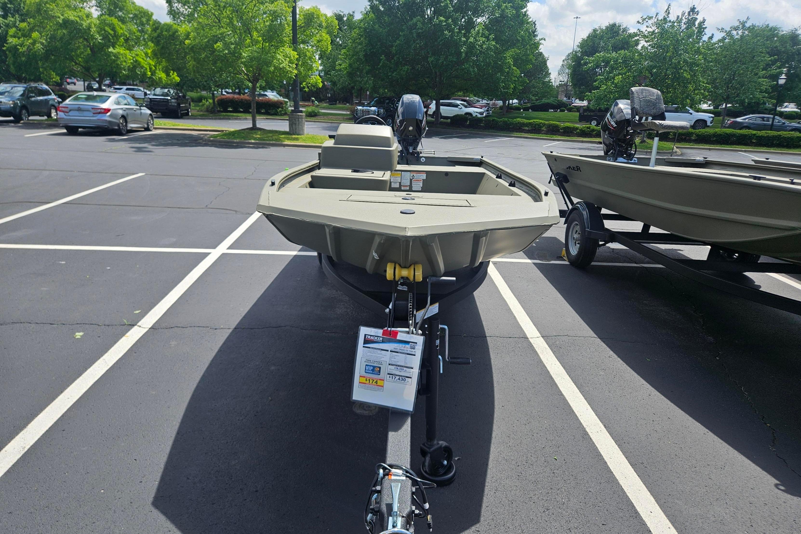 2026 Tracker Grizzly 1648 SC boat on trailer in parking lot.
