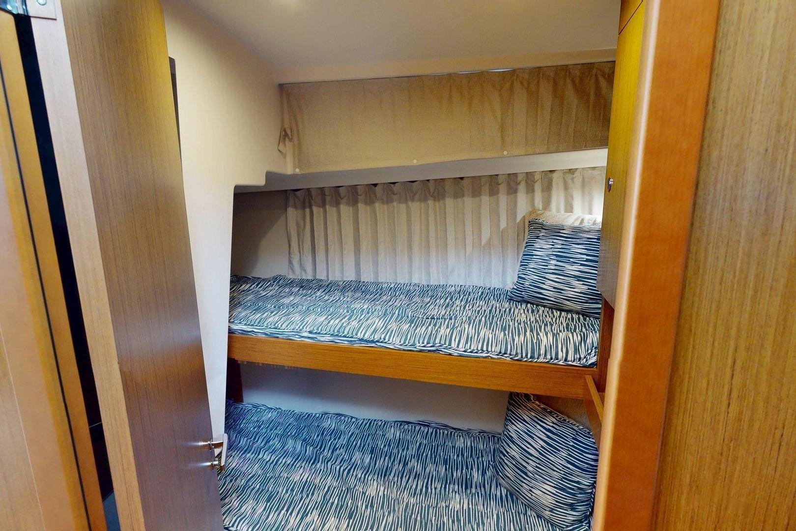2021 Beneteau Swift Trawler 35 cabin with bunk beds and patterned bedding.