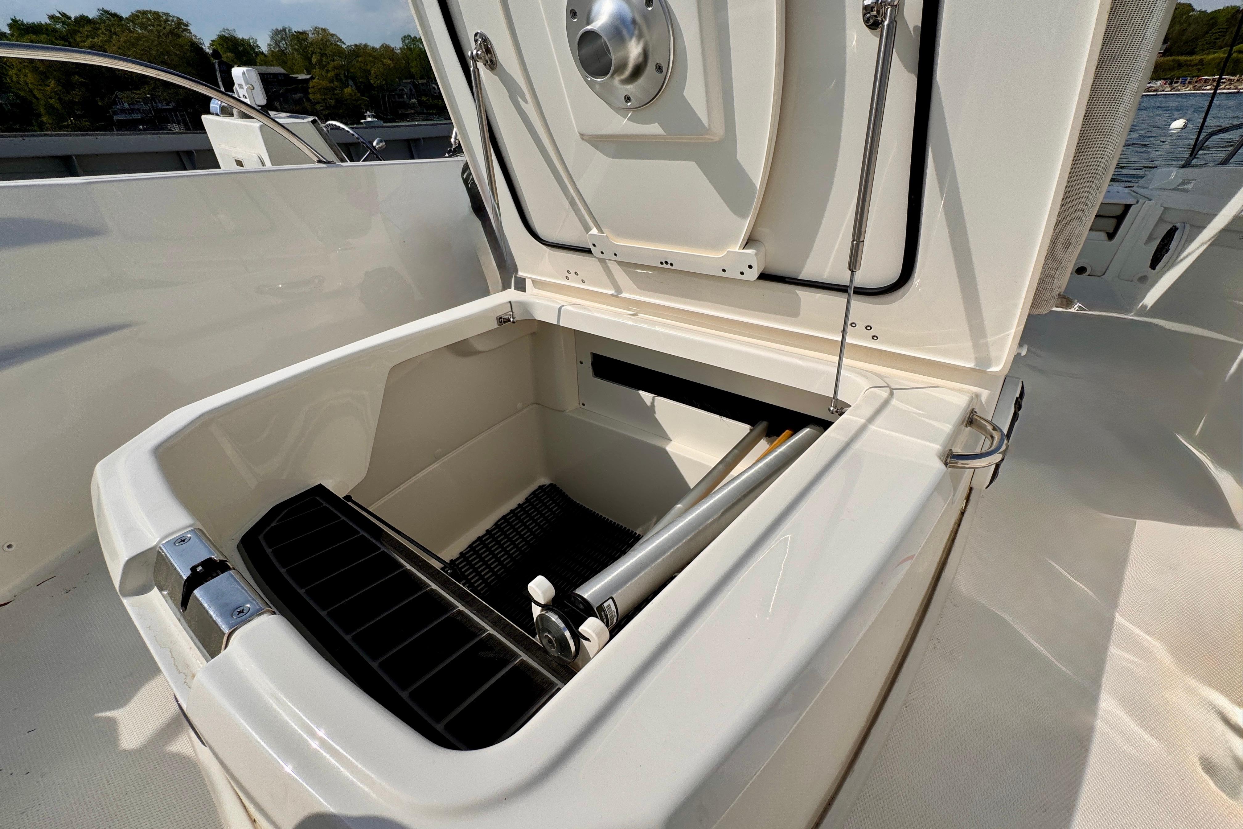 Open storage compartment on 2022 Boston Whaler 220 Dauntless boat, showcasing interior features.