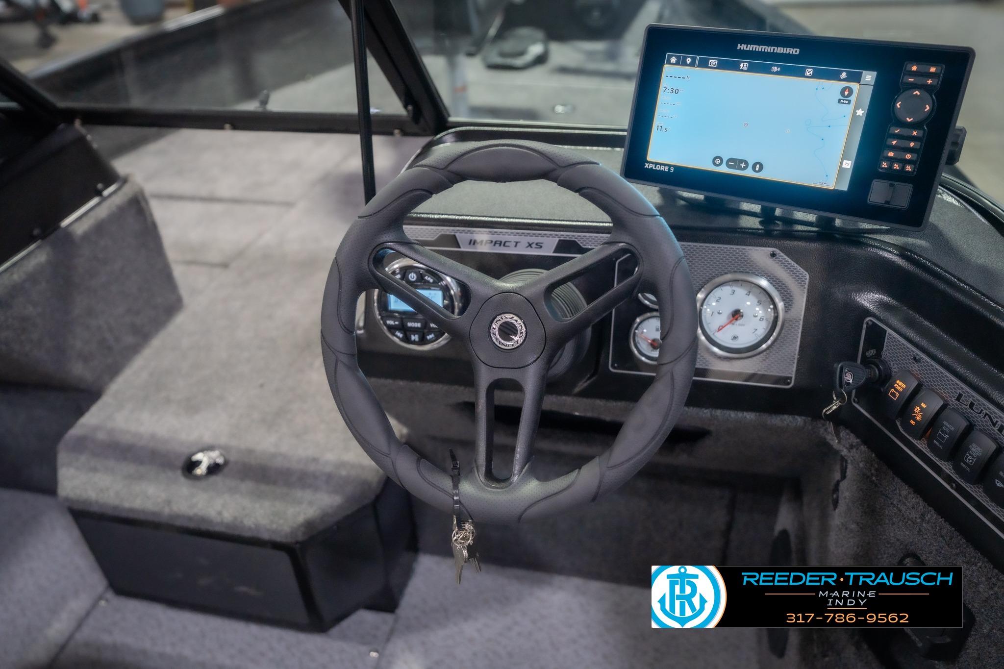 2026 Lund 2075 Impact XS boat dashboard with steering wheel and navigation display.