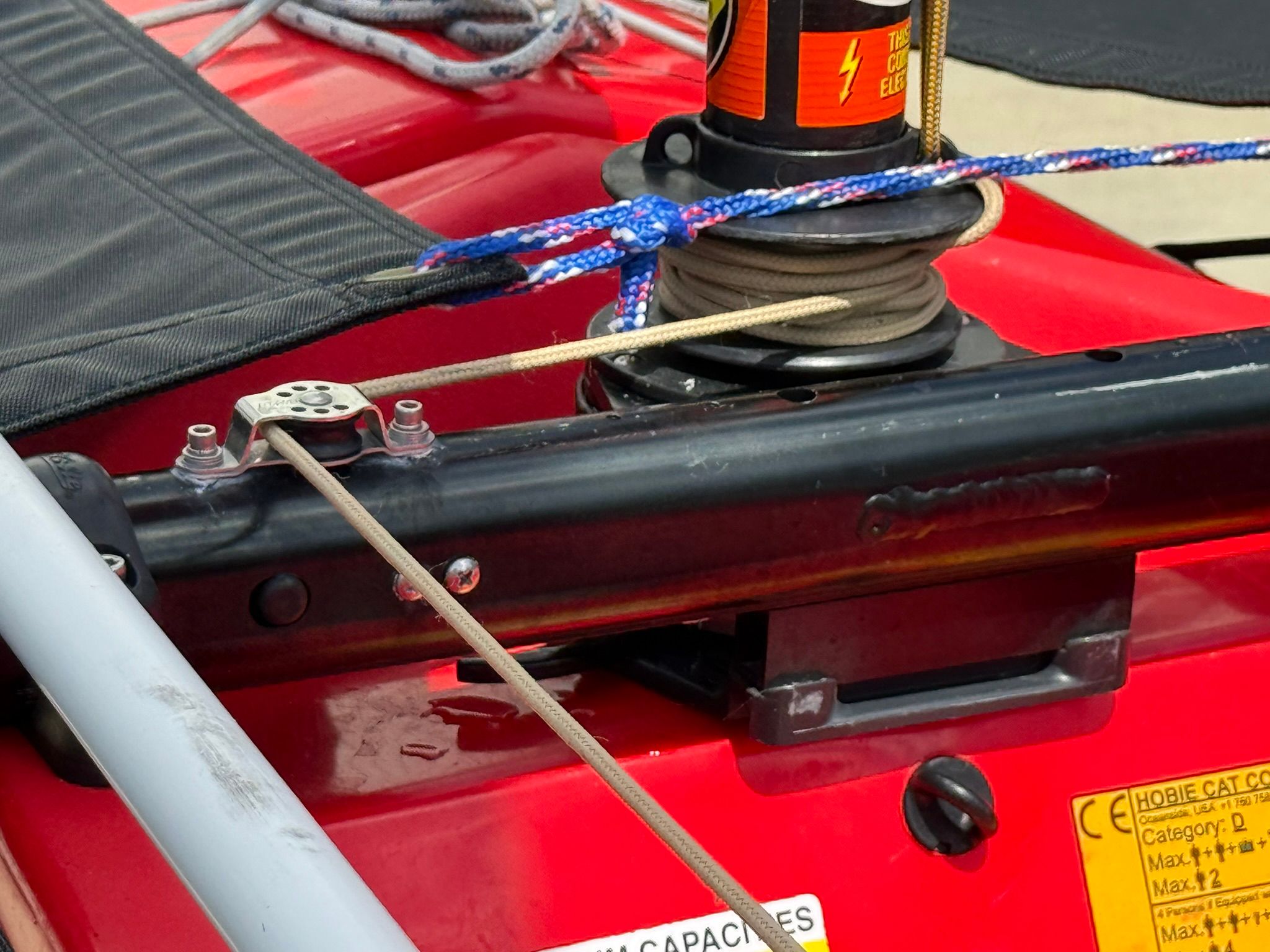 Close-up of a red Hobie Mirage Tandem Island with ropes and sailing equipment.