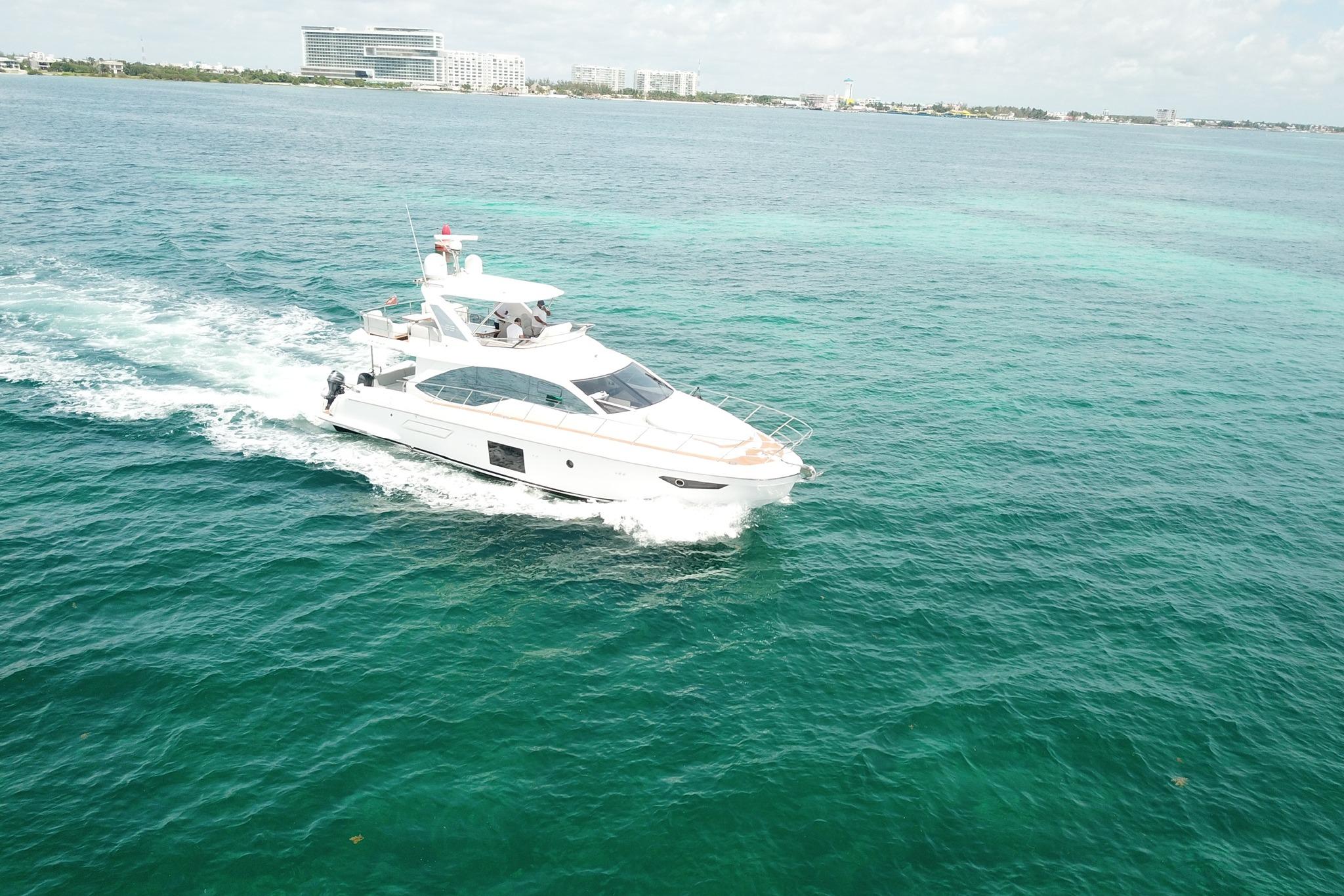 Luxury Azimut 55 yacht cruising in clear turquoise waters, 2021 model.