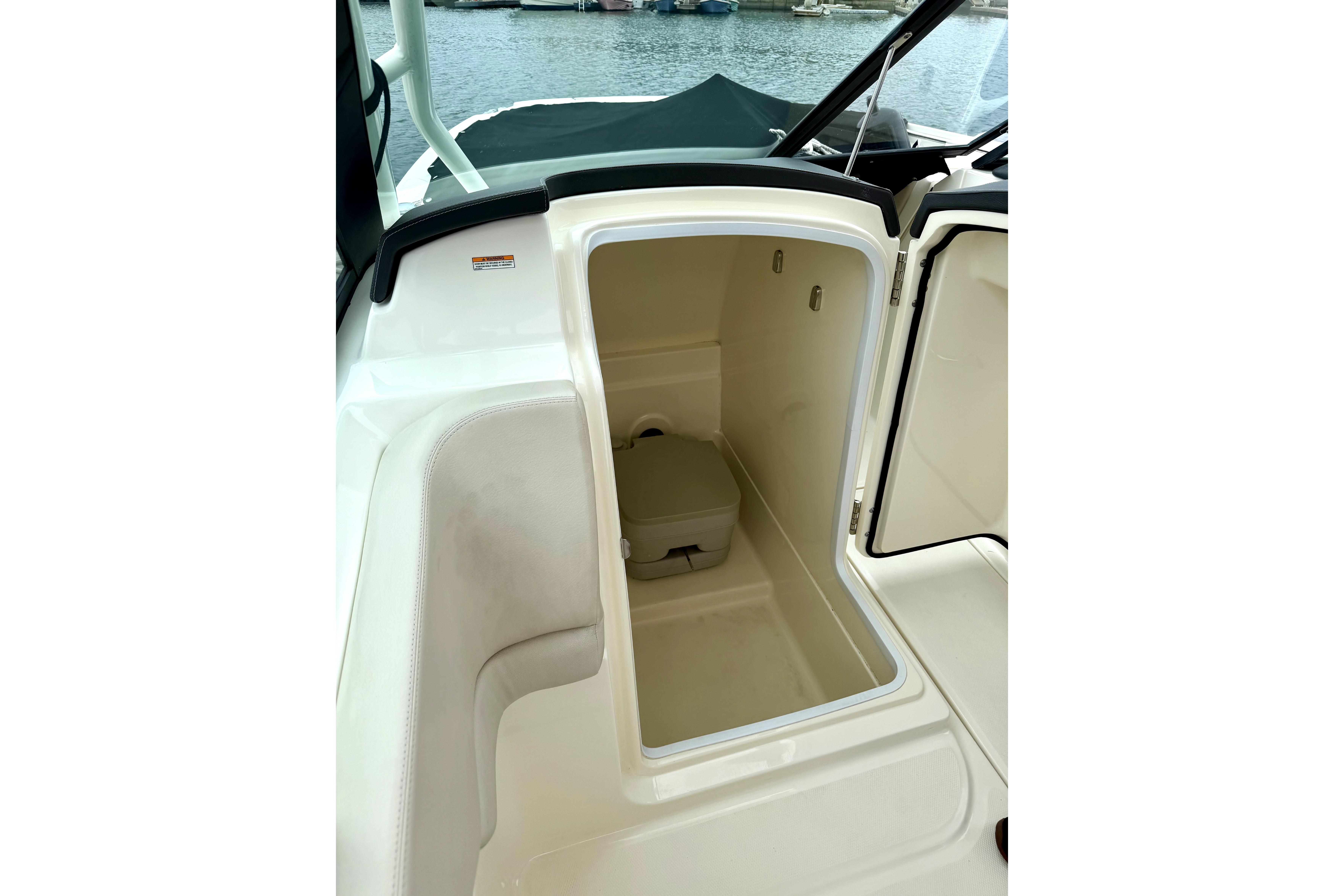 2017 Boston Whaler 230 Vantage boat storage compartment with open hatch, dockside view.