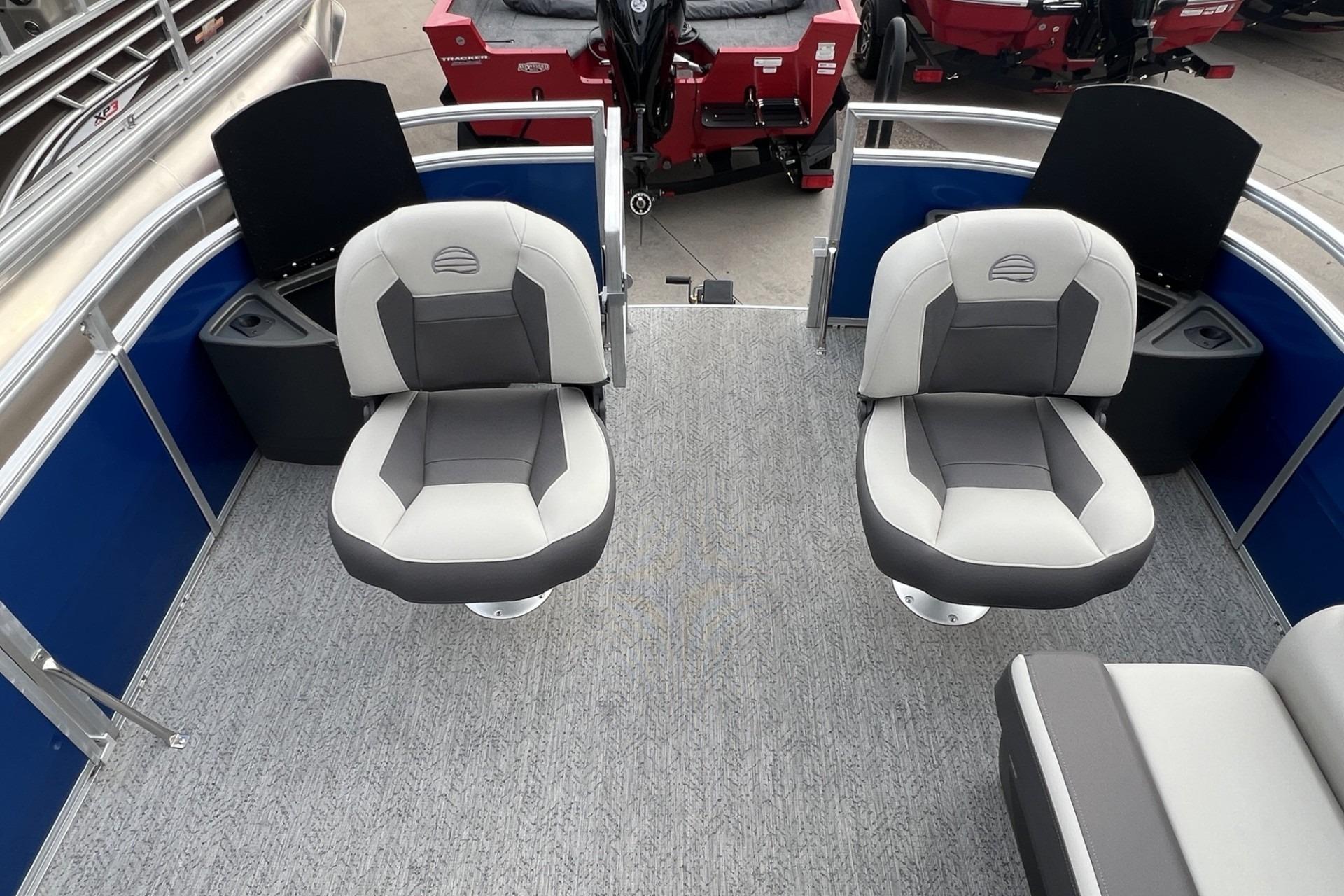2026 Sun Tracker Fishin' Barge 20 DLX interior with two swivel seats and carpeted floor.