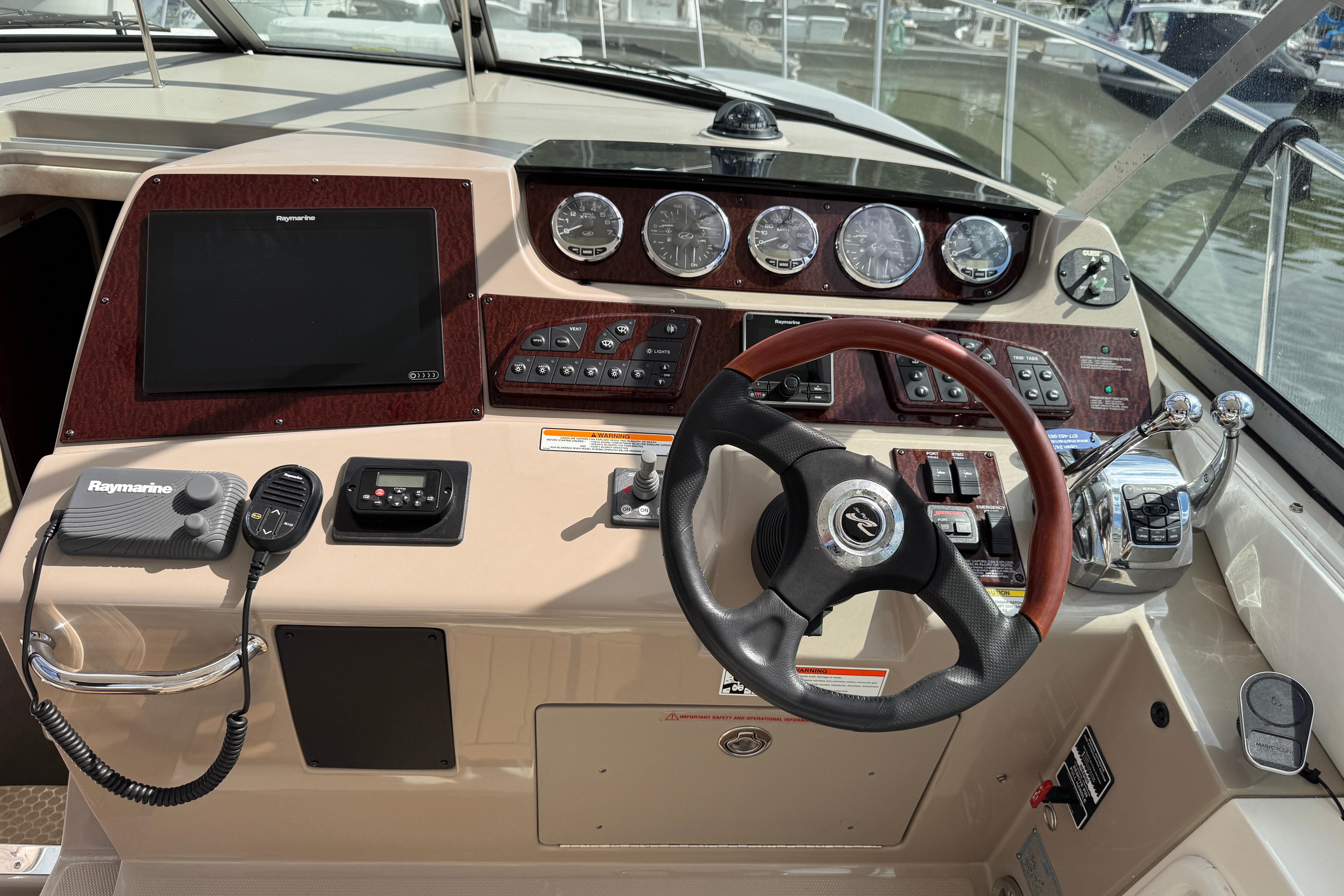 Control panel of a 2008 Sea Ray Sundancer 350 boat with steering wheel and gauges.
