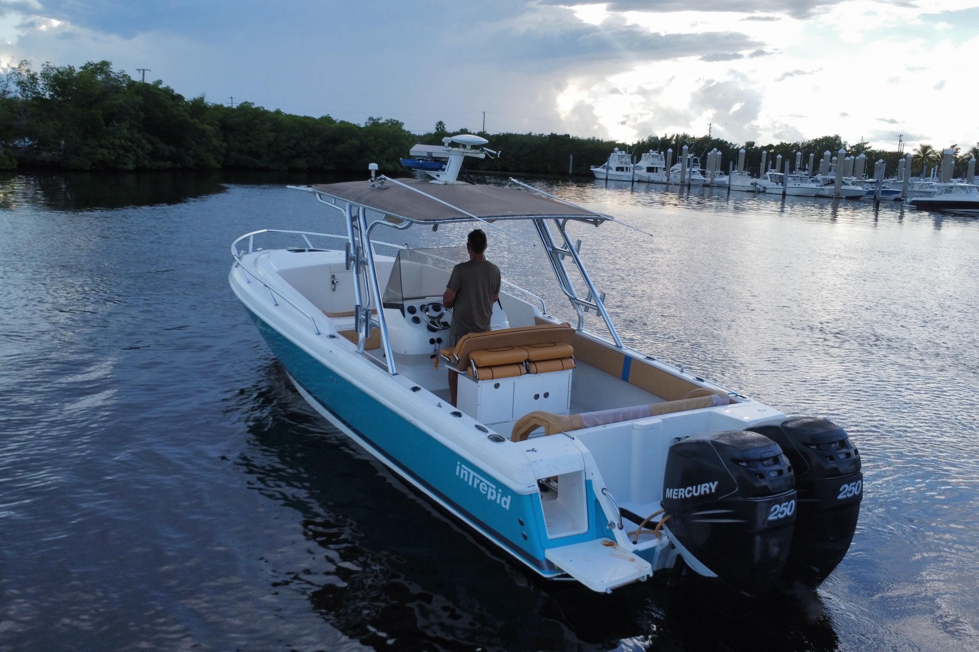 2005 Intrepid 323 Cuddy boat with dual Mercury engines on calm water.