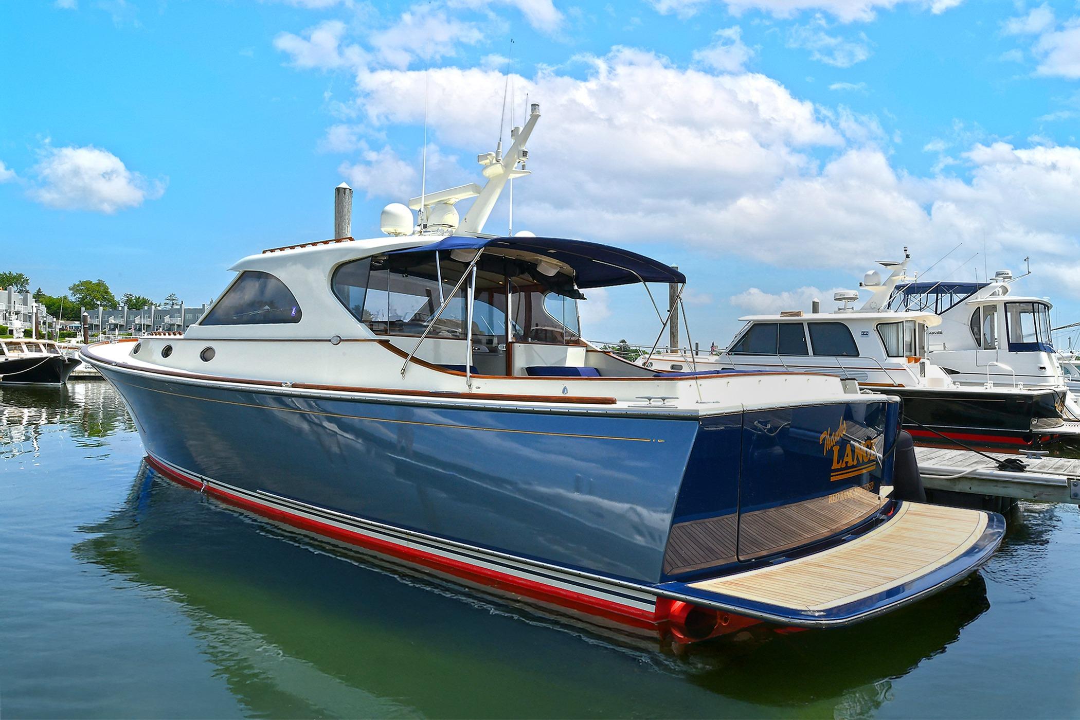 2005 San Juan Downeast Express yacht docked in a marina under a blue sky.