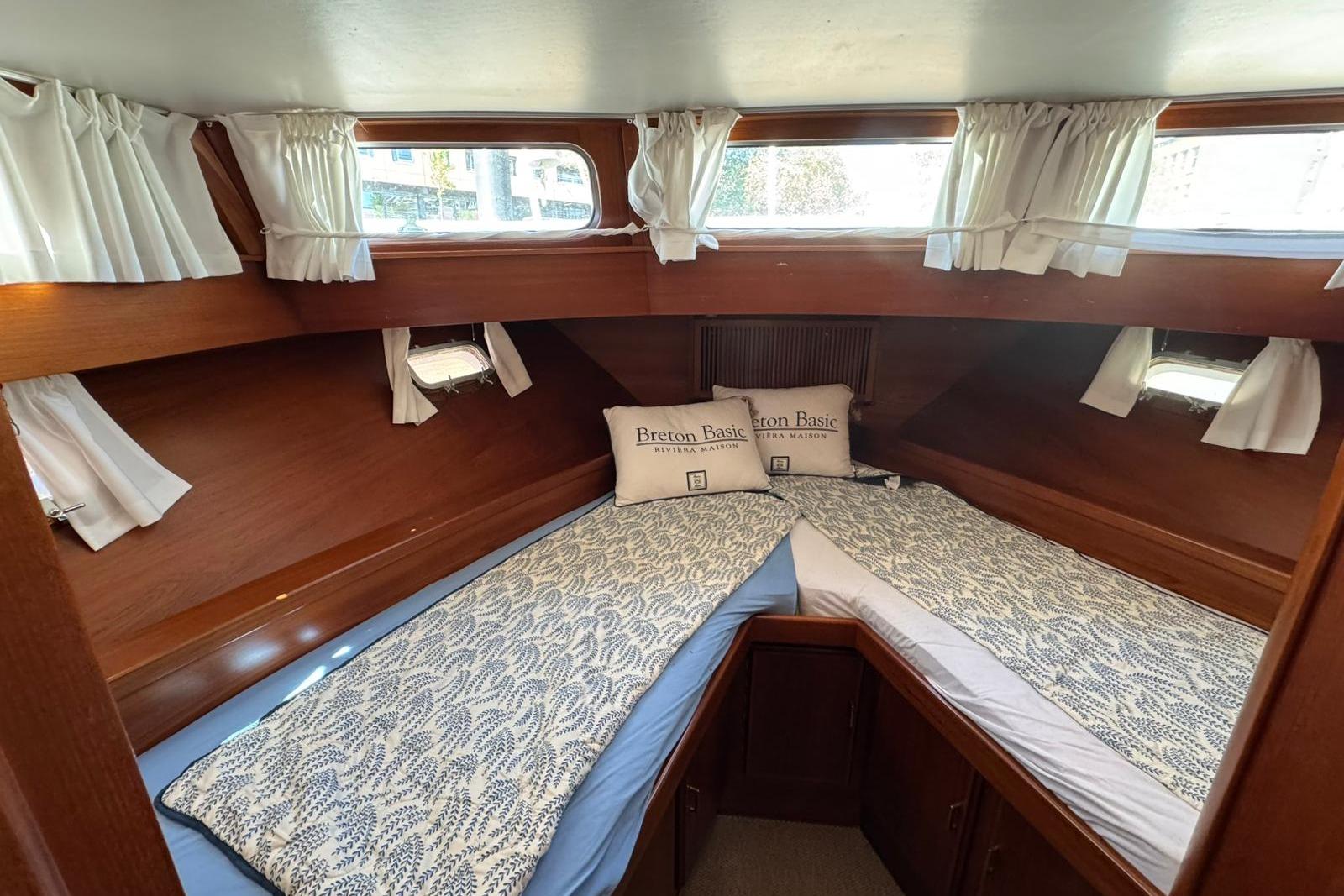 Cozy cabin interior of 1991 Super Van Craft 15.50 yacht with twin beds and curtains.