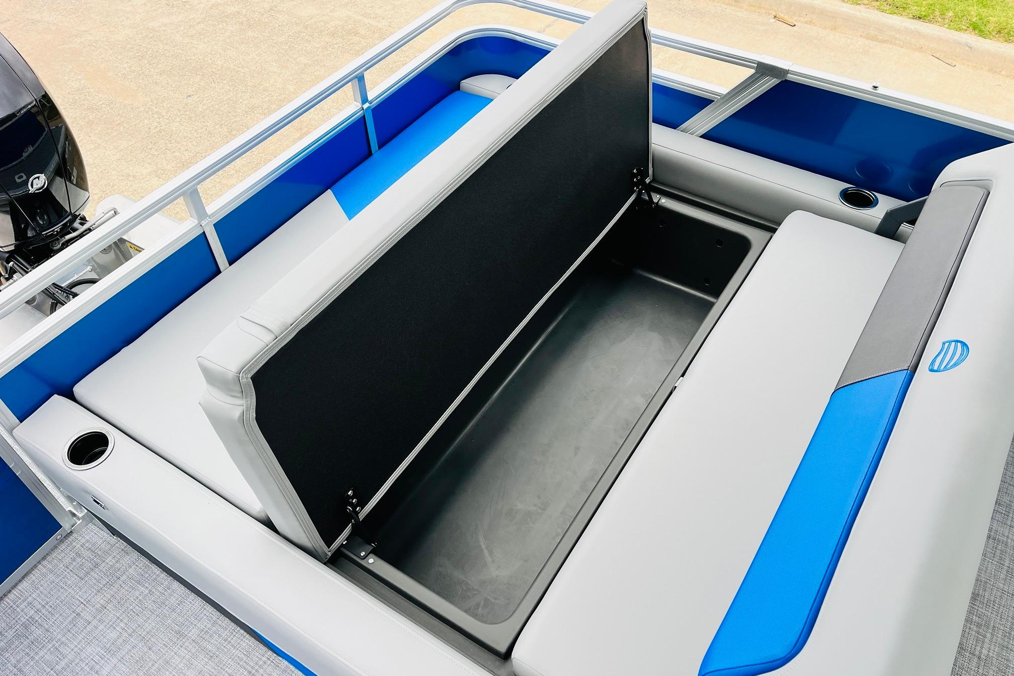 2026 Sun Tracker Party Barge 22 RF DLX with open storage compartment and blue-gray seating.