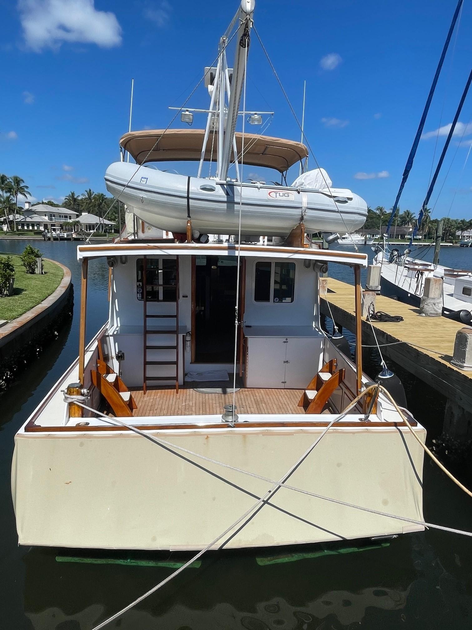 1979 Jarvis Newman Trawler docked at marina with inflatable boat on top.