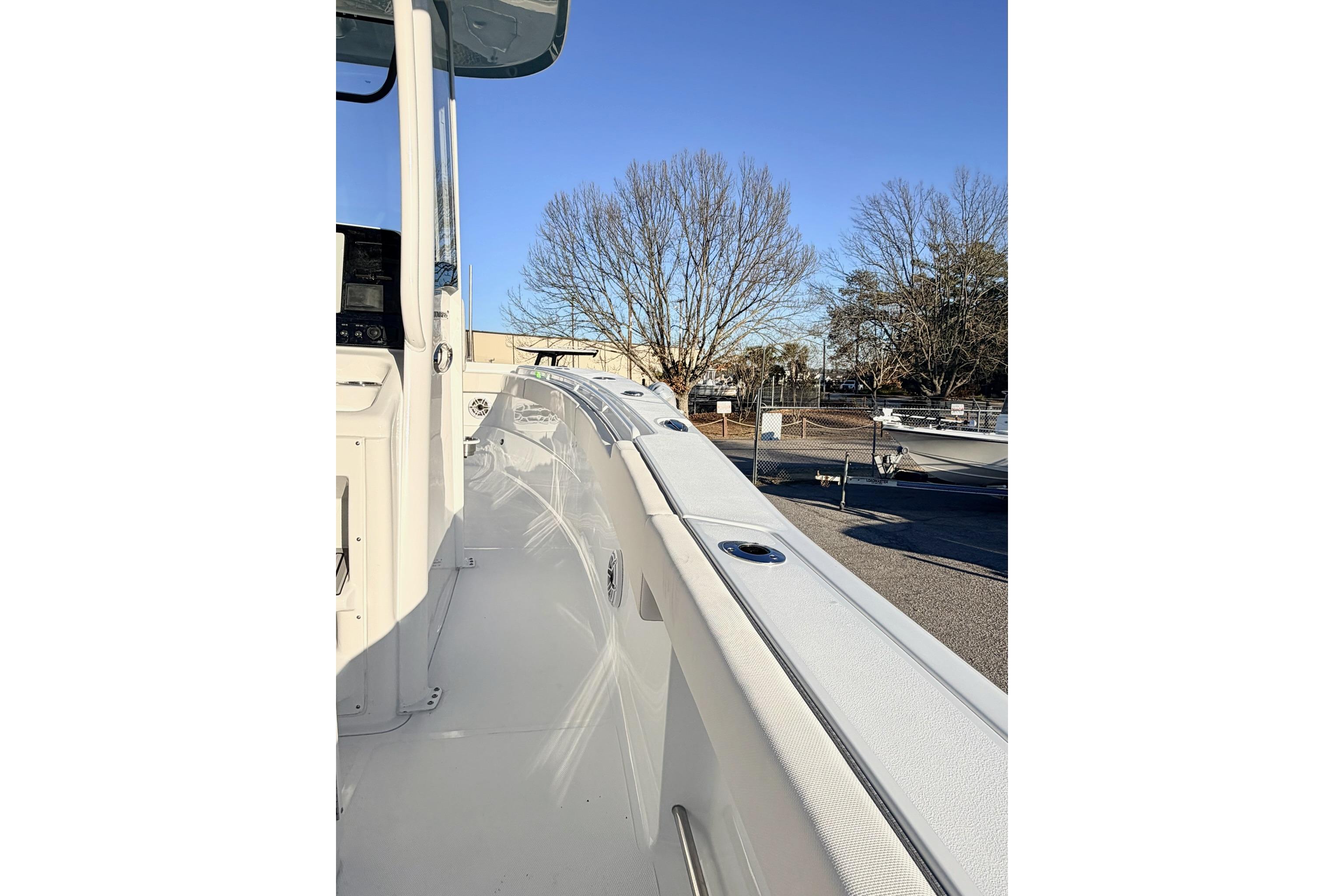 2026 Sea Hunt Ultra 275 Coffin Box boat, side view, docked under clear blue sky.