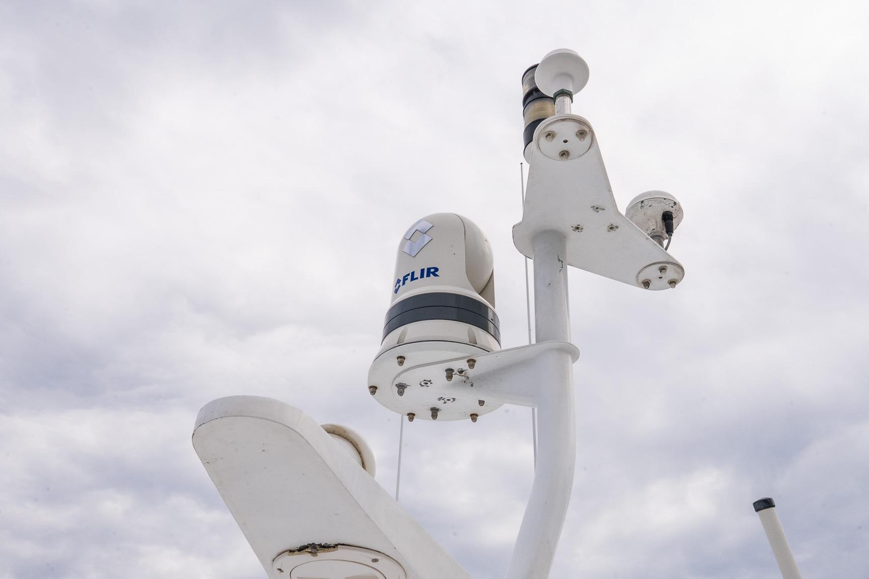 Radar and camera equipment on 2002 Viking 61 Enclosed Bridge yacht against cloudy sky.