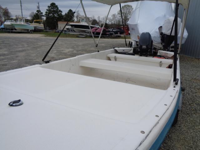 2010 Sundance K14T boat with outboard motor in a gravel lot.