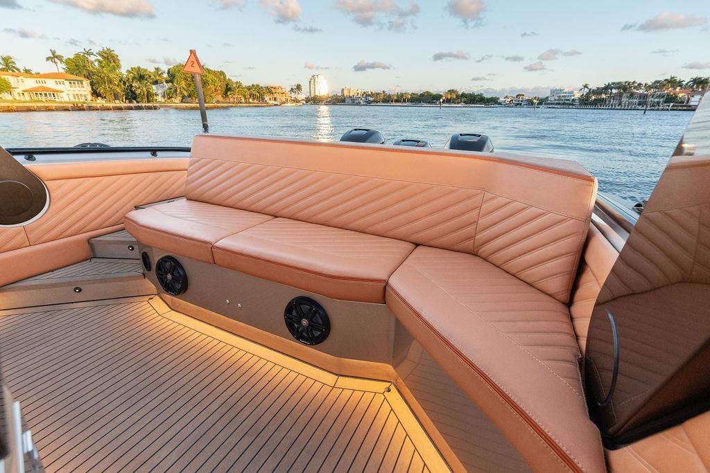 Luxurious seating on 2023 DeKoning 43 boat, with scenic waterfront view.