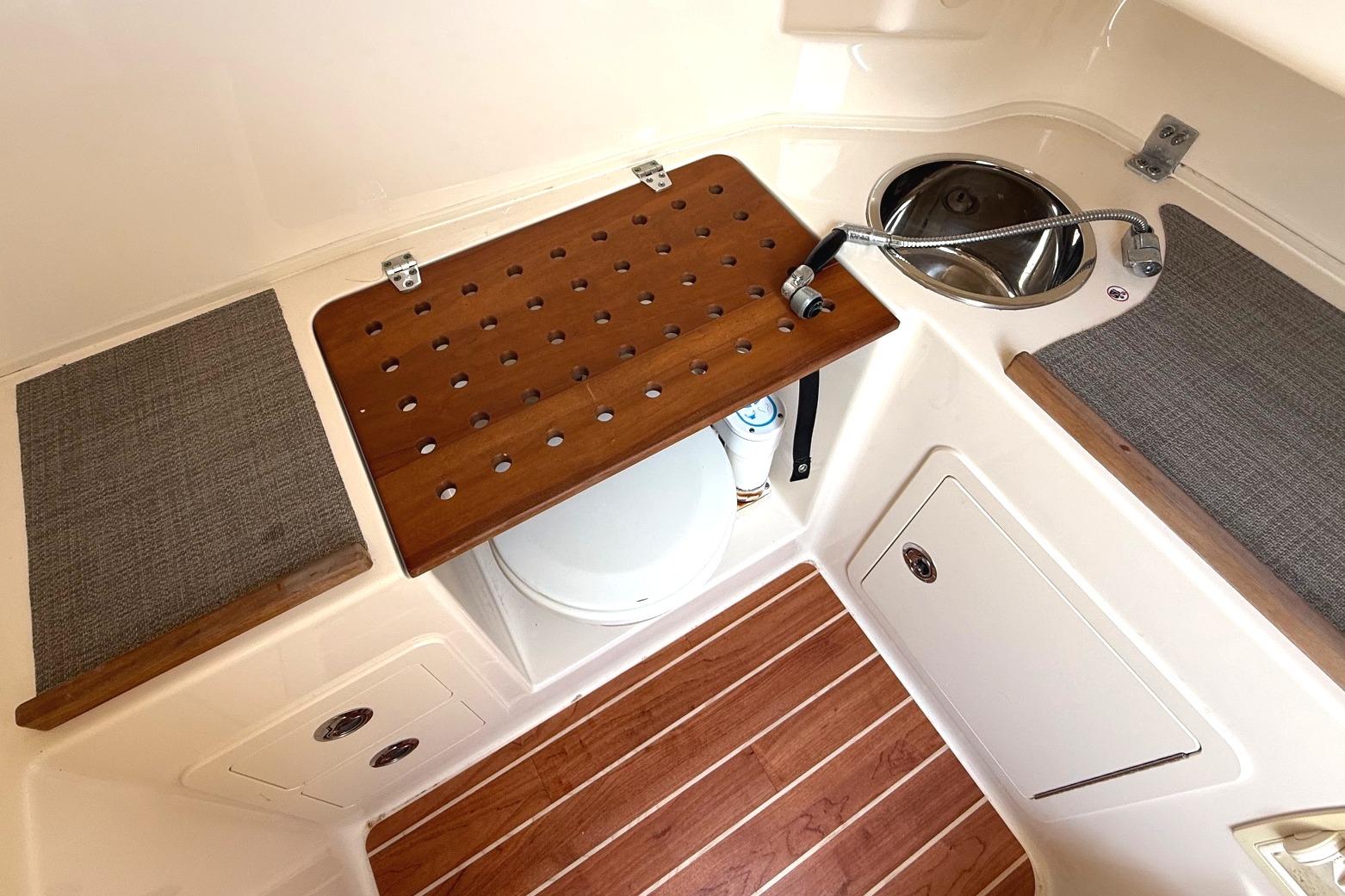 2018 Grady-White Canyon 306 boat interior with sink, wooden accents, and storage.