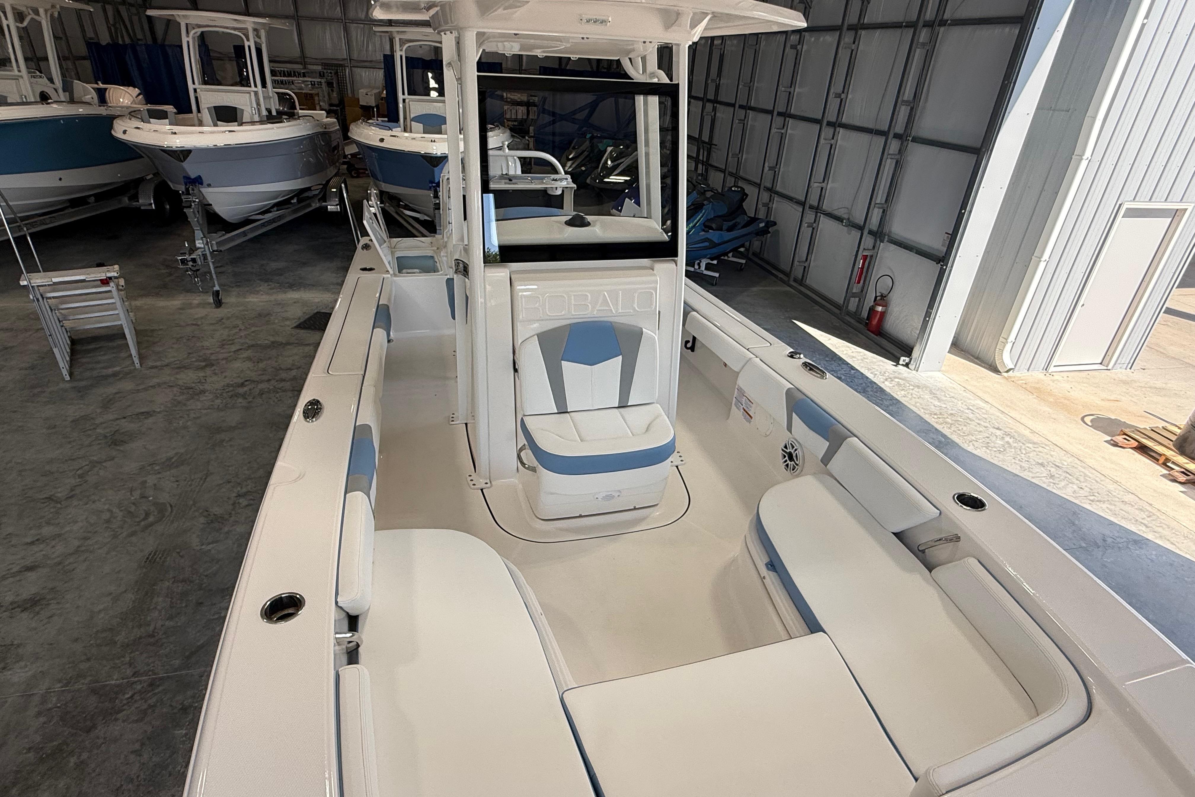 2026 Robalo 246 Cayman boat interior in a showroom, featuring spacious seating and modern design.