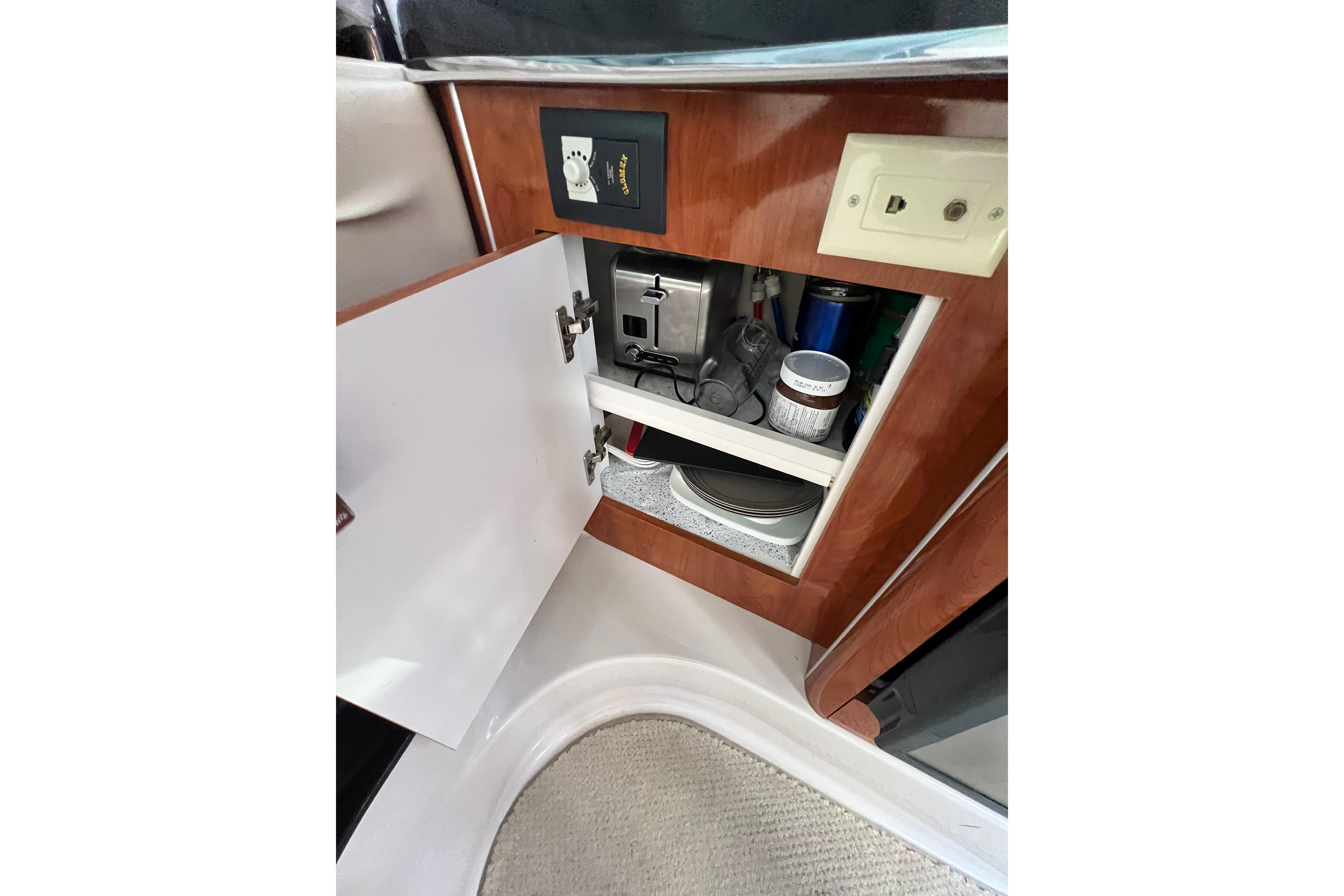 Open cabinet in 2011 Doral 28 Prestancia boat, showing storage shelves and electrical outlets.