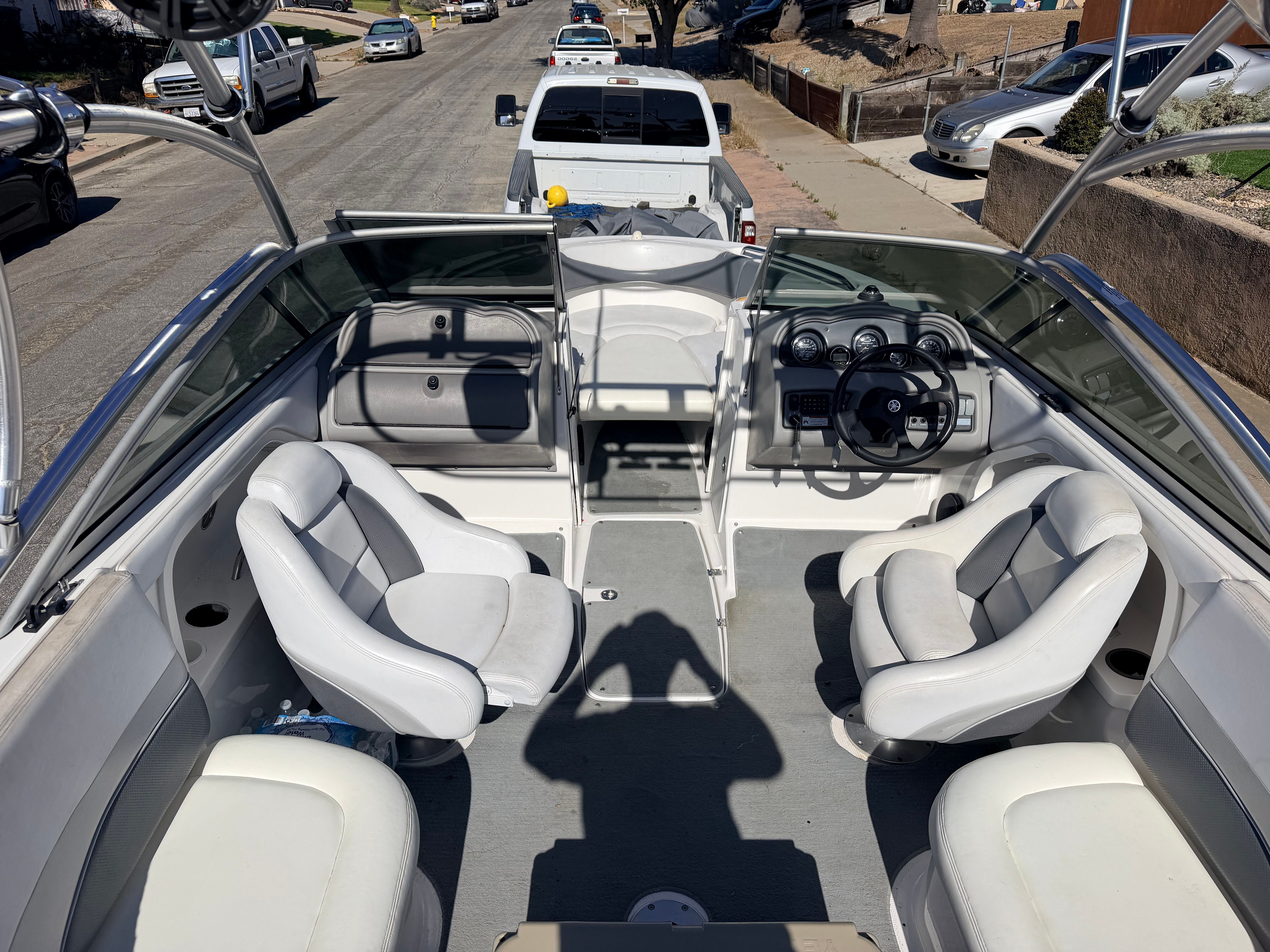 Interior view of a 2005 Yamaha AR230 boat with white seats and a steering console.