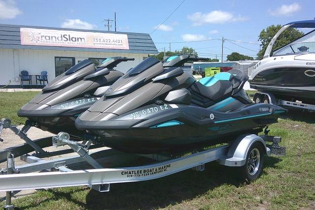 2023 Yamaha FX Cruiser HO jet skis on trailer at dealership, sunny day.