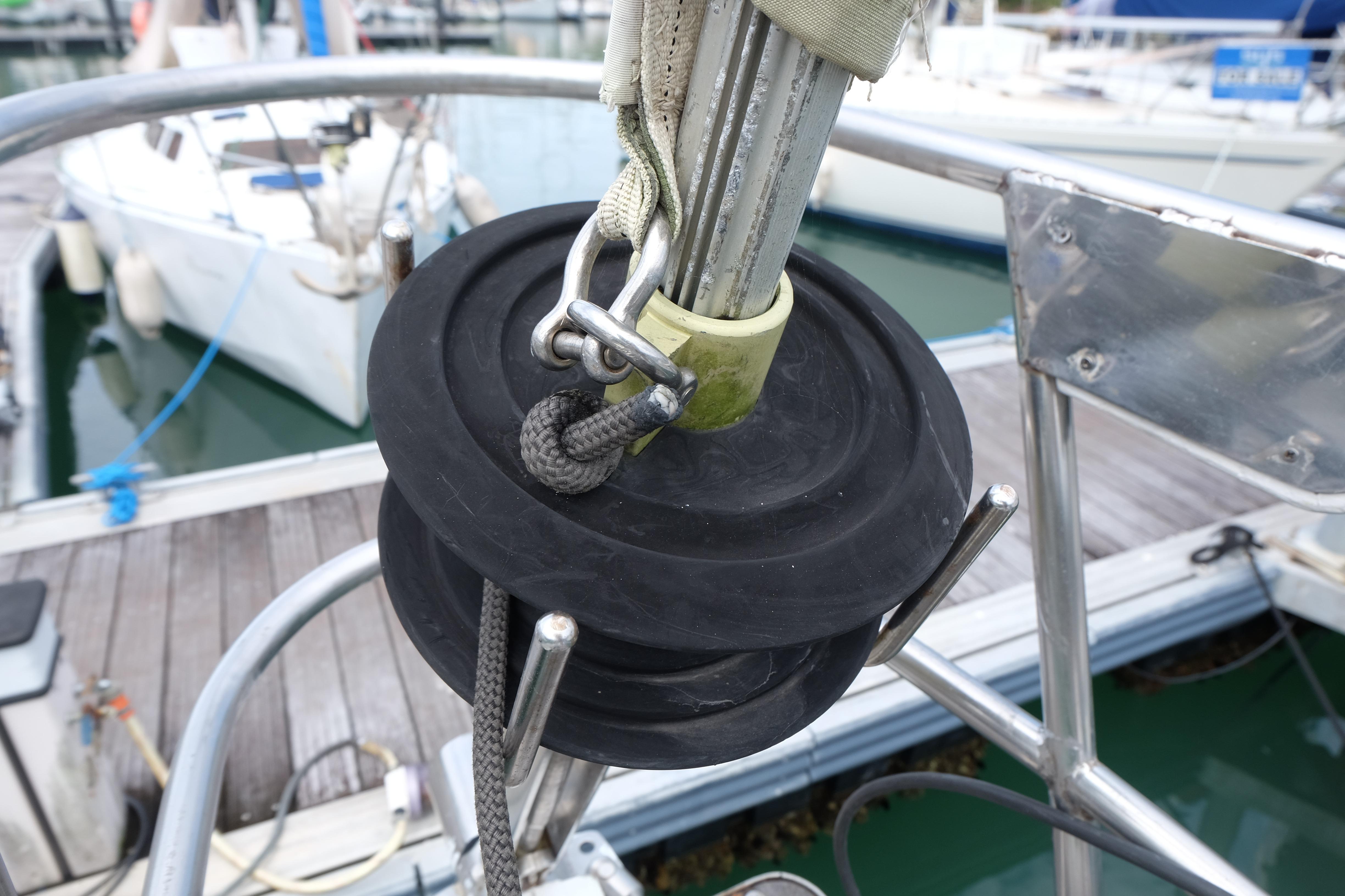 Close-up of a 1979 Westwind 35 sailboat's rigging and pulley system at a marina.