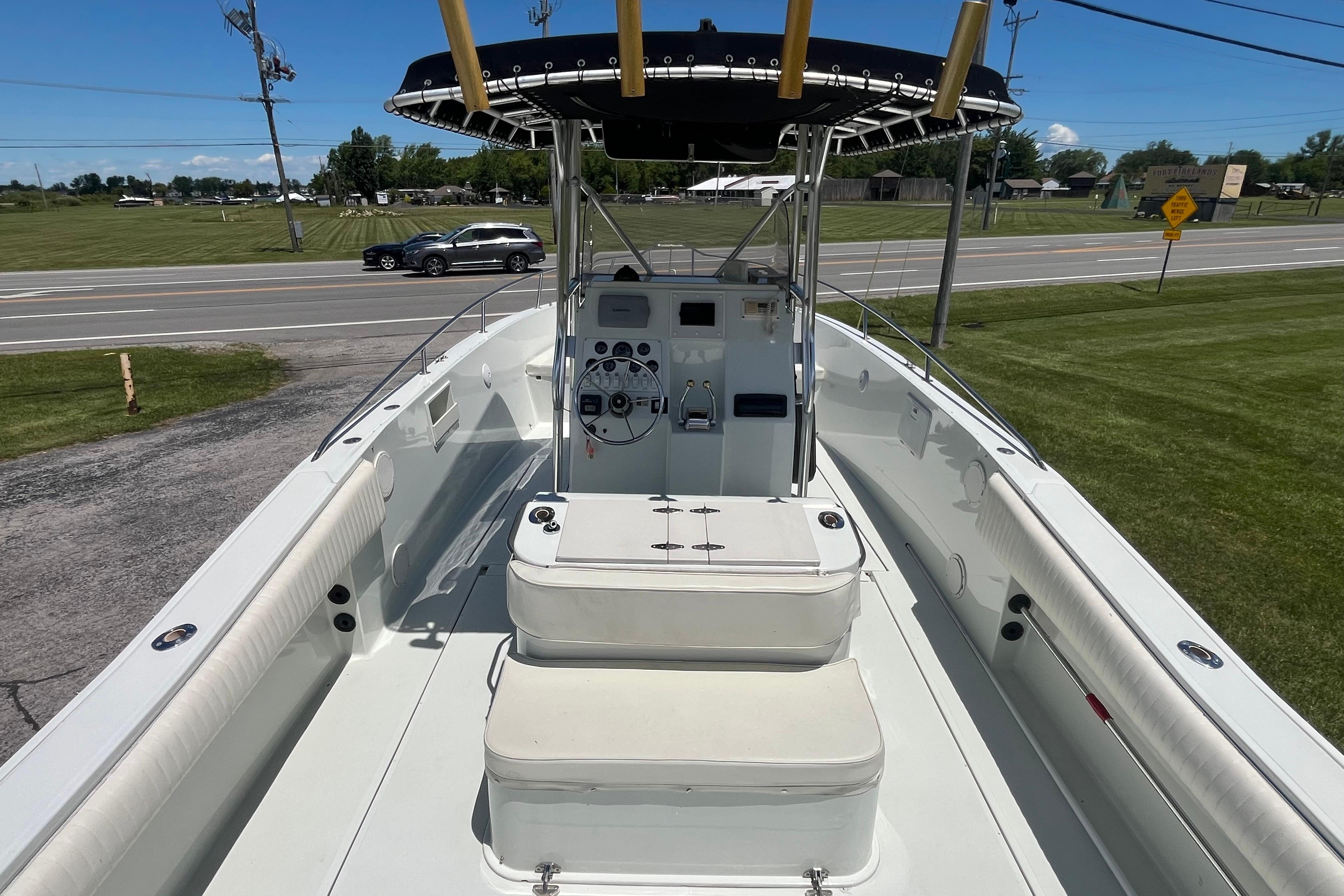 1997 Stamas boat with center console and seating, parked near a road.