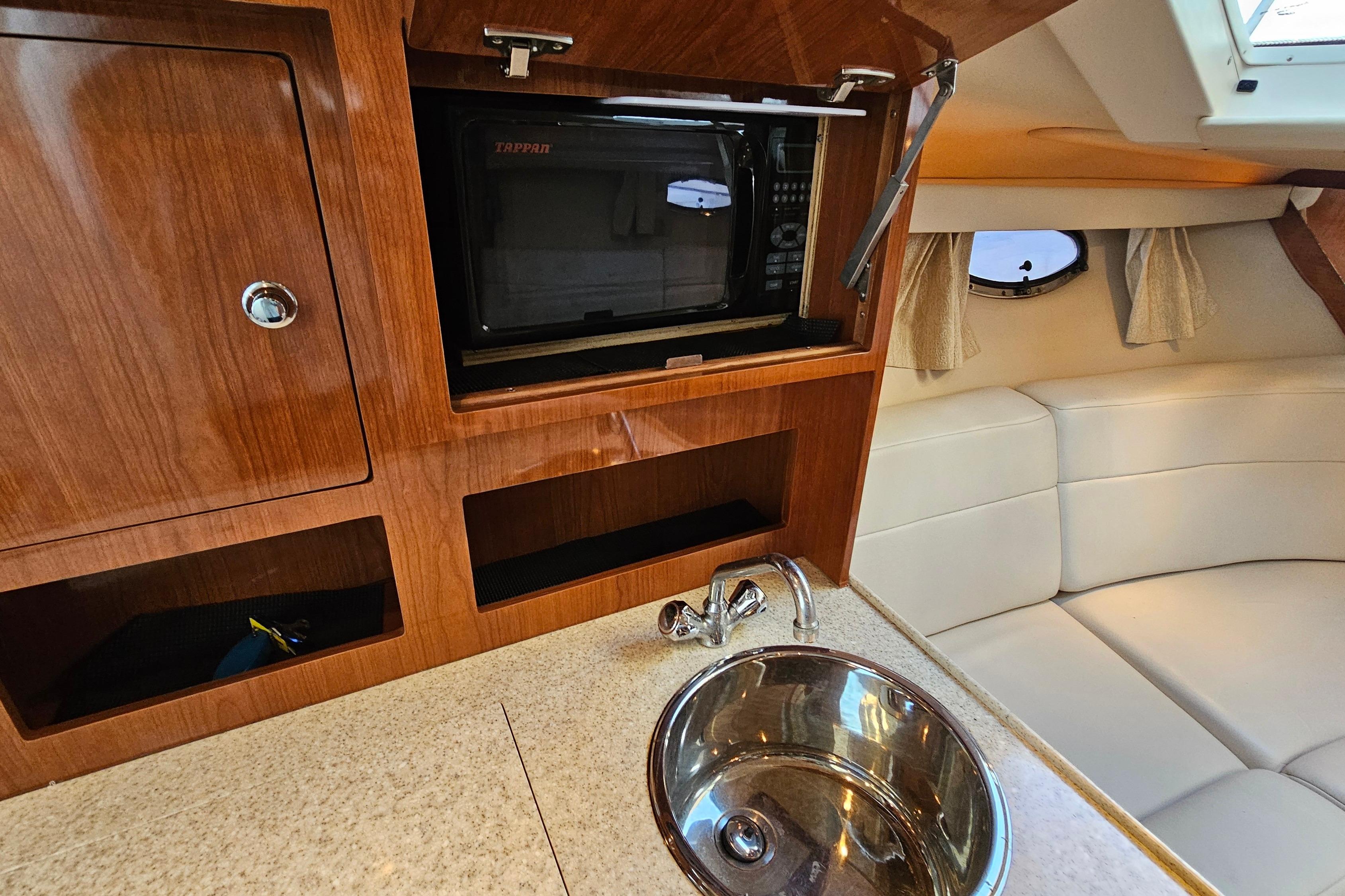 2005 Regal 3060 Window Express interior with microwave, sink, and seating area.