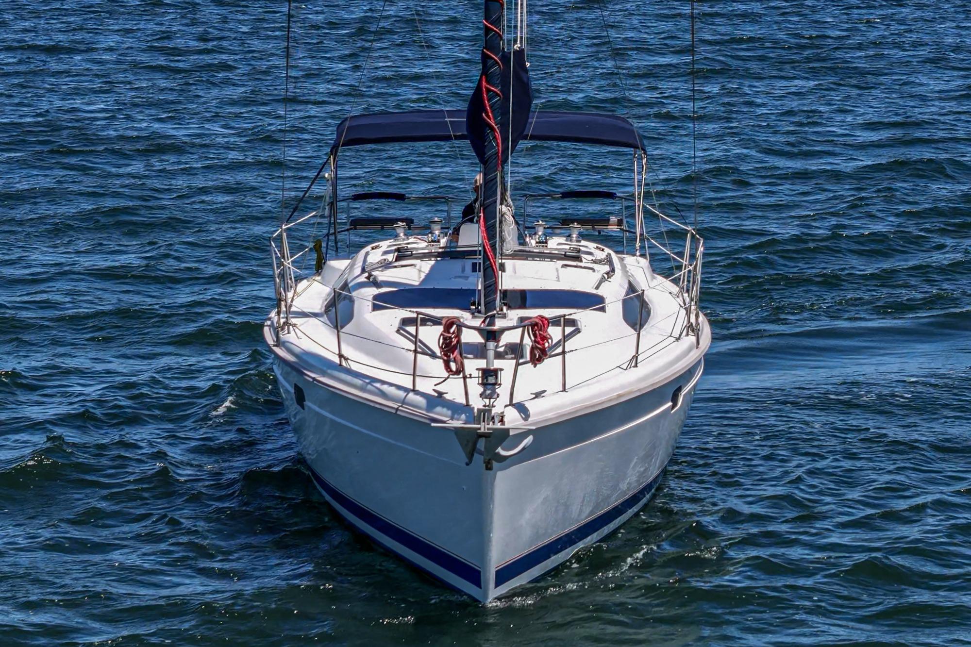 Sailboat on water, 1996 Hunter 376 model, front view with blue canopy.