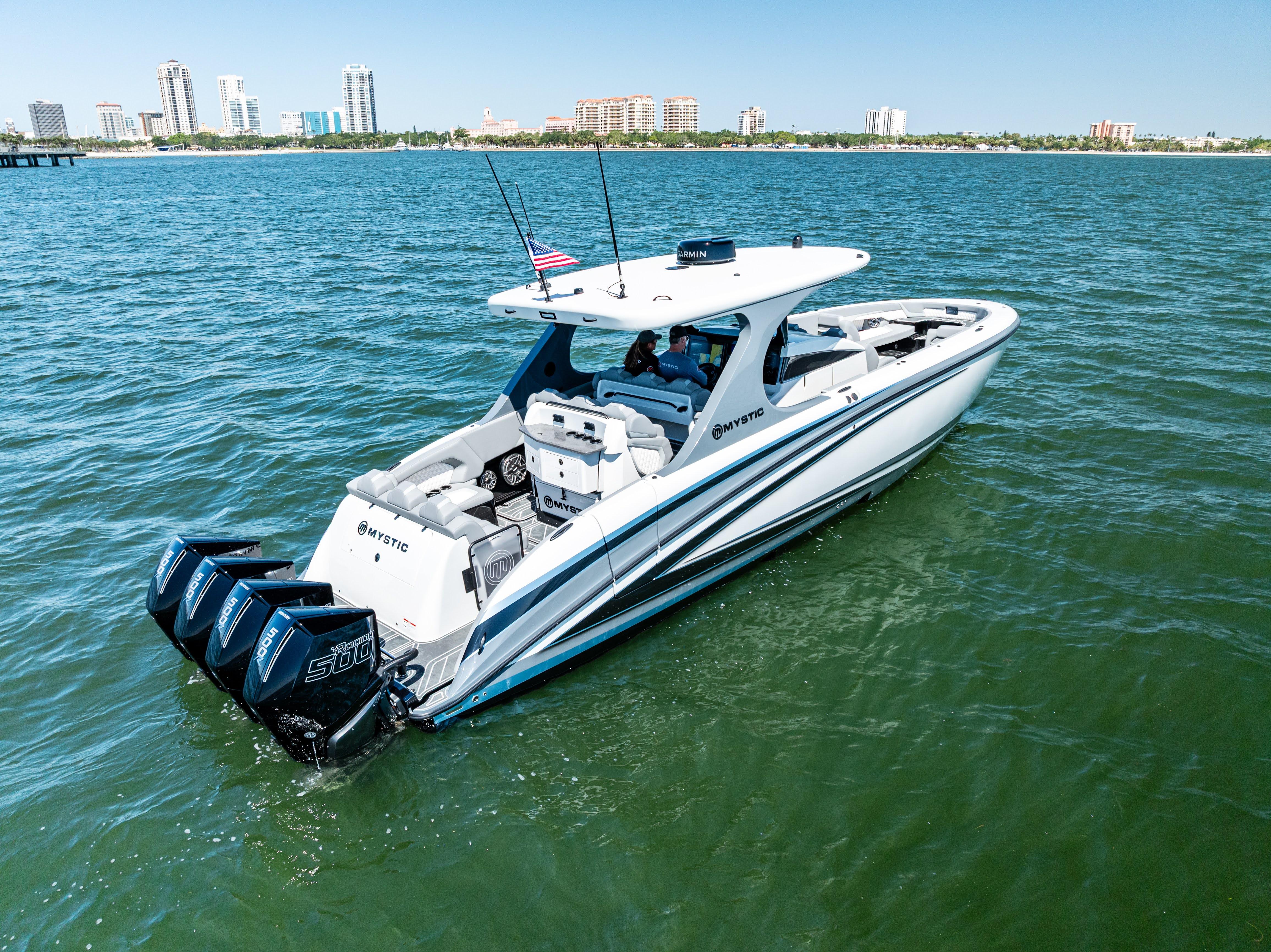 2026 Mystic Powerboats M4200 cruising on water with city skyline in background.